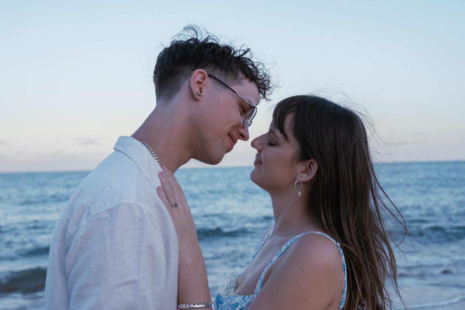 A couple shares intimate moments on a beach at sunset in a series of romantic photographs.