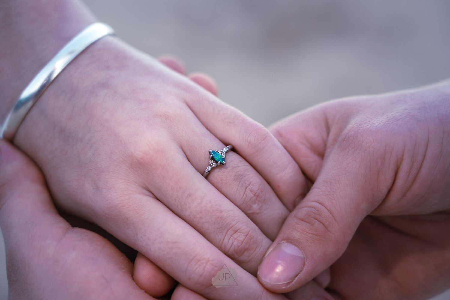 Close-up of hands exchanging wedding rings during a marriage ceremony.