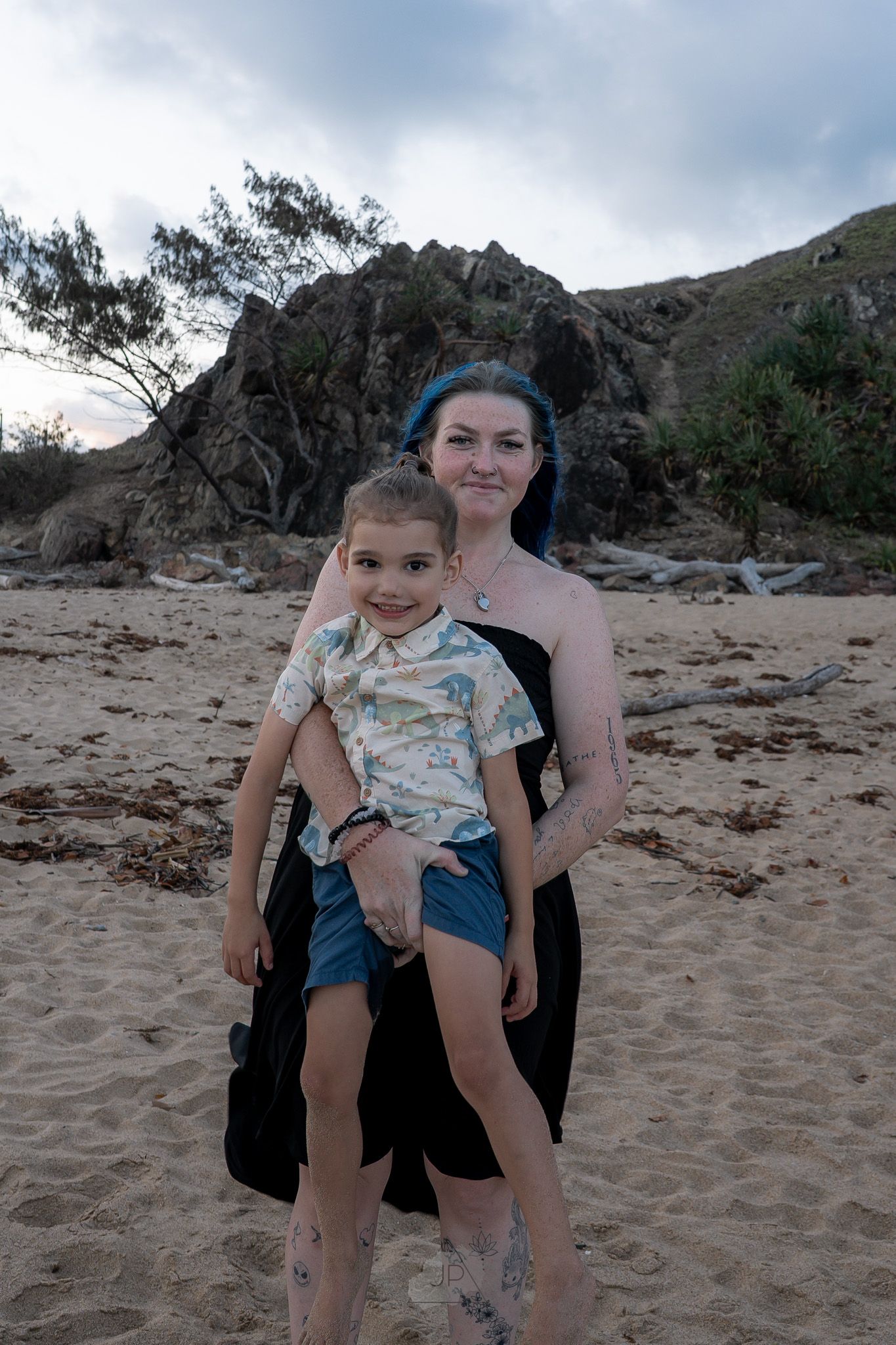 A series of beach photos showing a child being playfully lifted and spun in the sand against a cloudy mountain backdrop.
