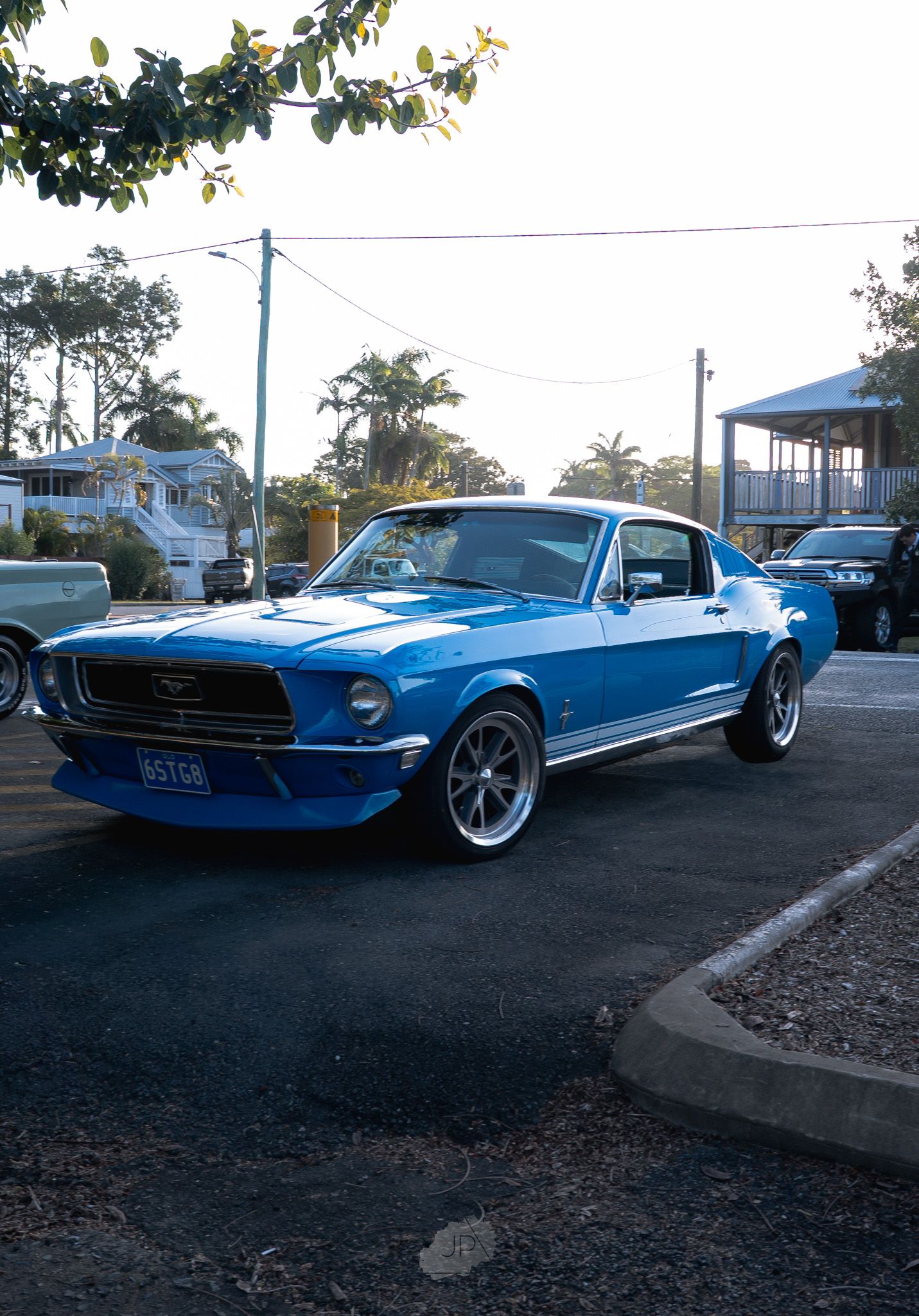 A classic blue Ford Mustang fastback shown from multiple angles parked on pavement with custom wheels and chrome trim.