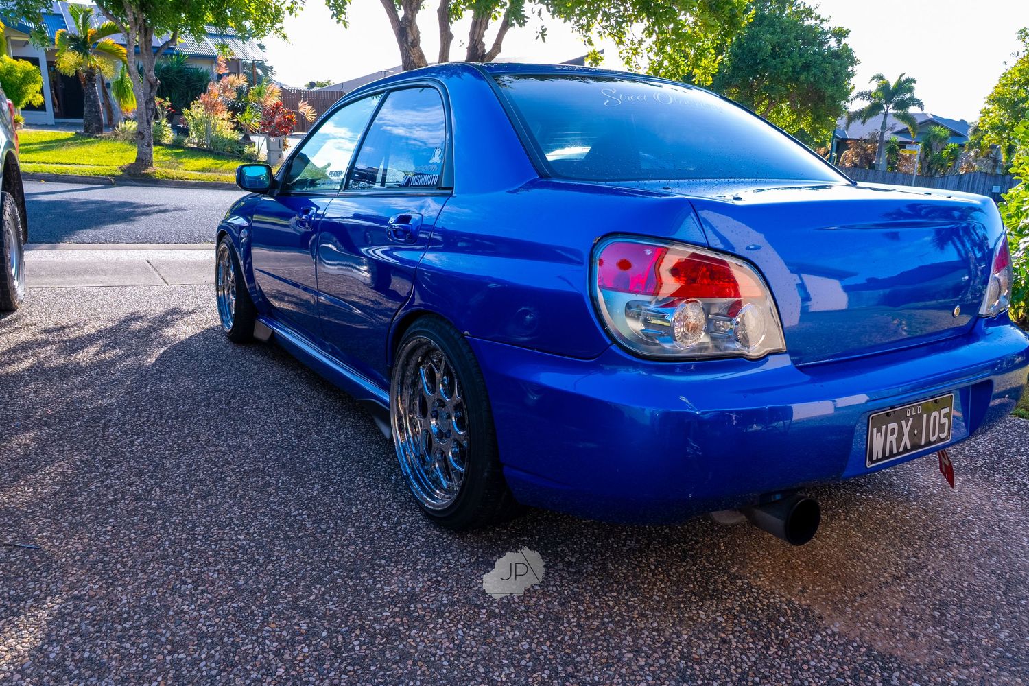 A bright blue Subaru WRX with custom modifications shown from multiple angles on a sunny day.