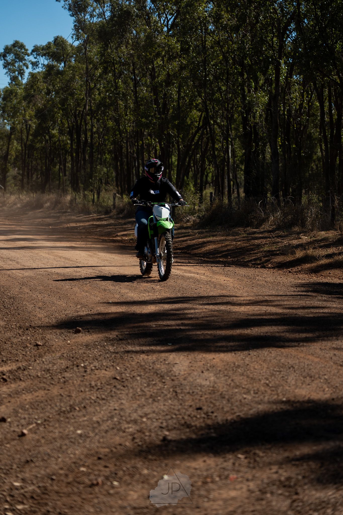 Series of sequential shots showing a cyclist riding on a dirt trail through a dense wooded forest area.