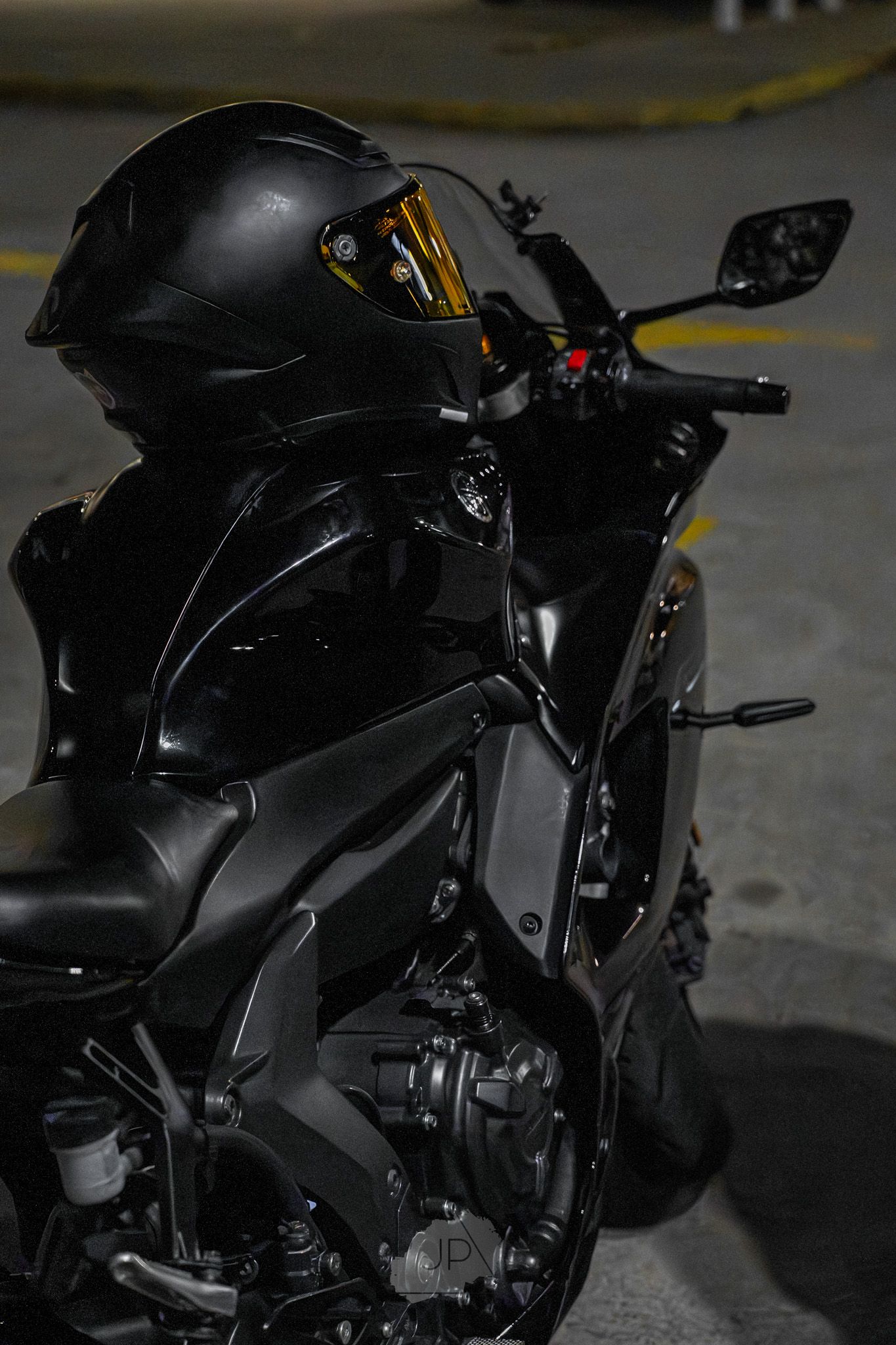 Black sport motorcycle with sleek aerodynamic design photographed from multiple angles in low light conditions.