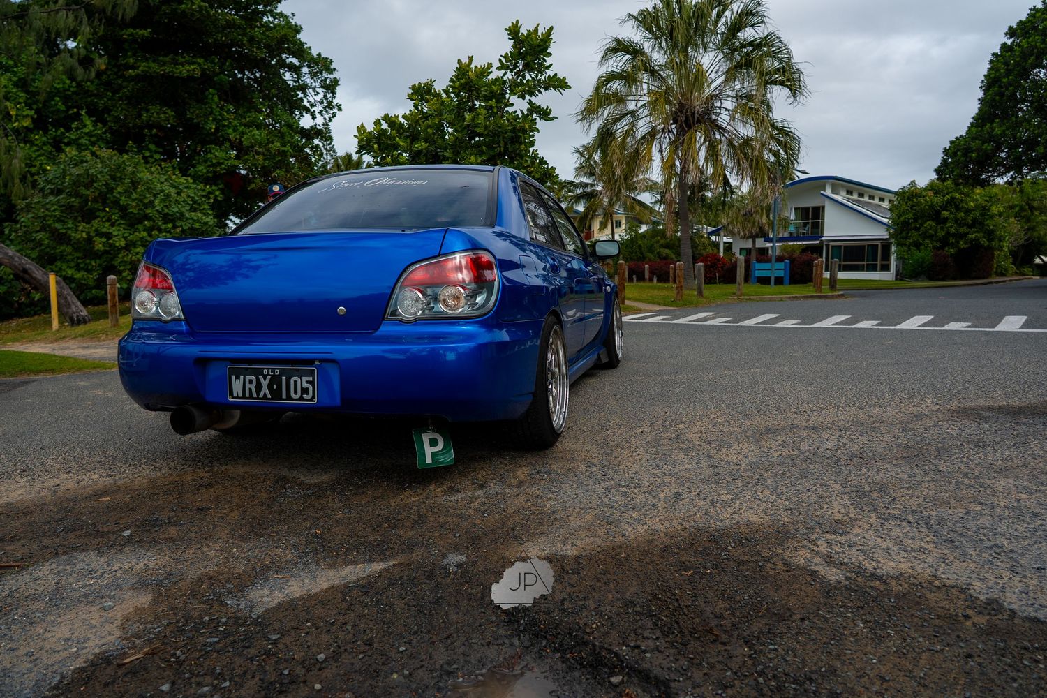 Multiple angles of a blue Subaru WRX STI showcasing its sporty exterior design and palm tree surroundings.