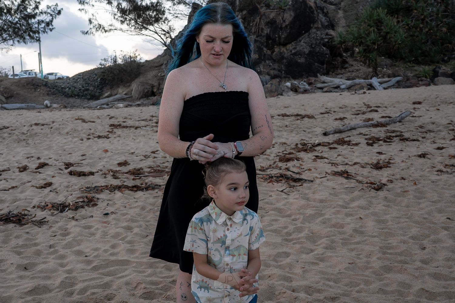 Family enjoys a peaceful moment together while sitting on a sandy beach at sunset.