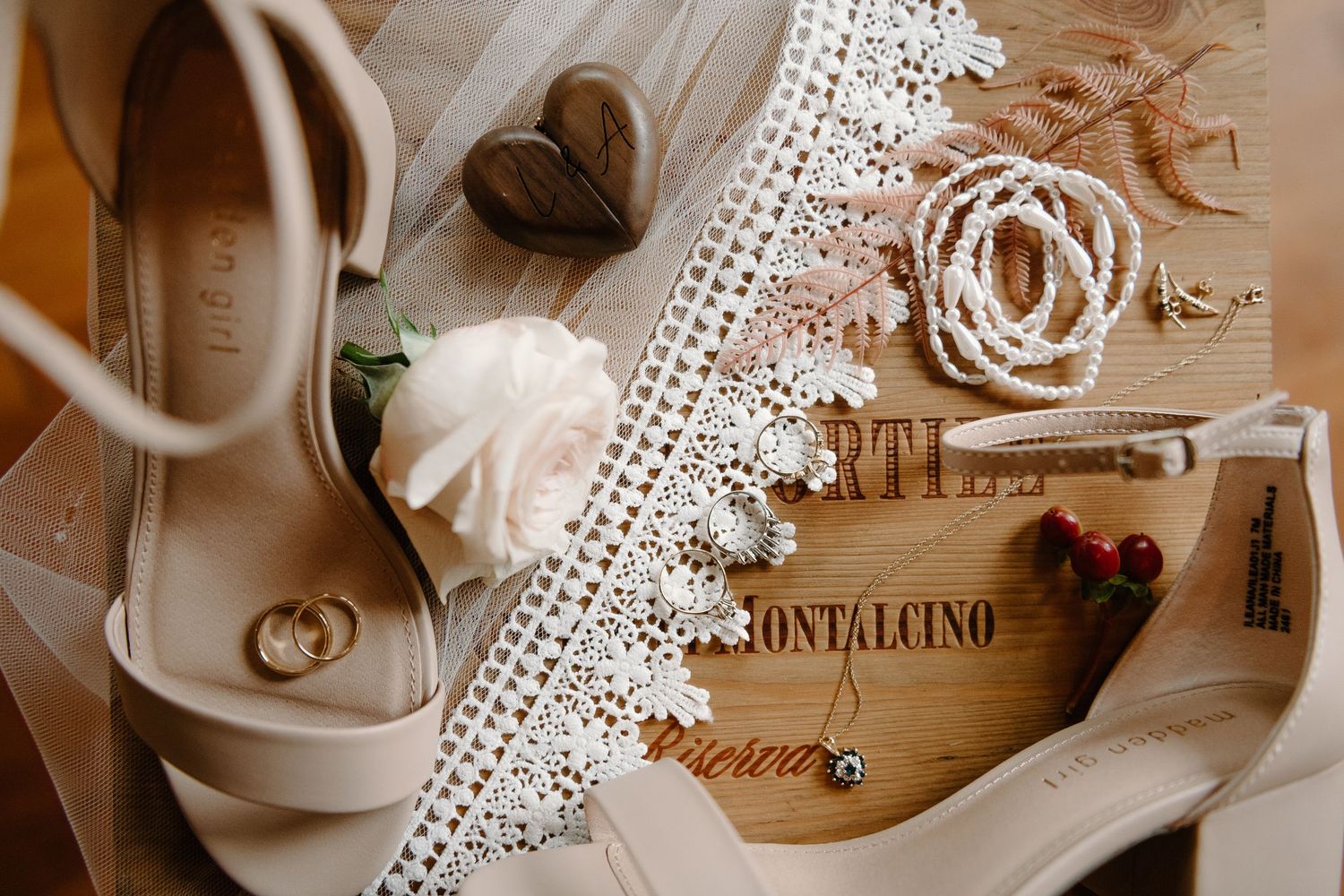 Vintage style flat lay with lace doily, white teacup, books, and floral elements on a rustic wooden surface.