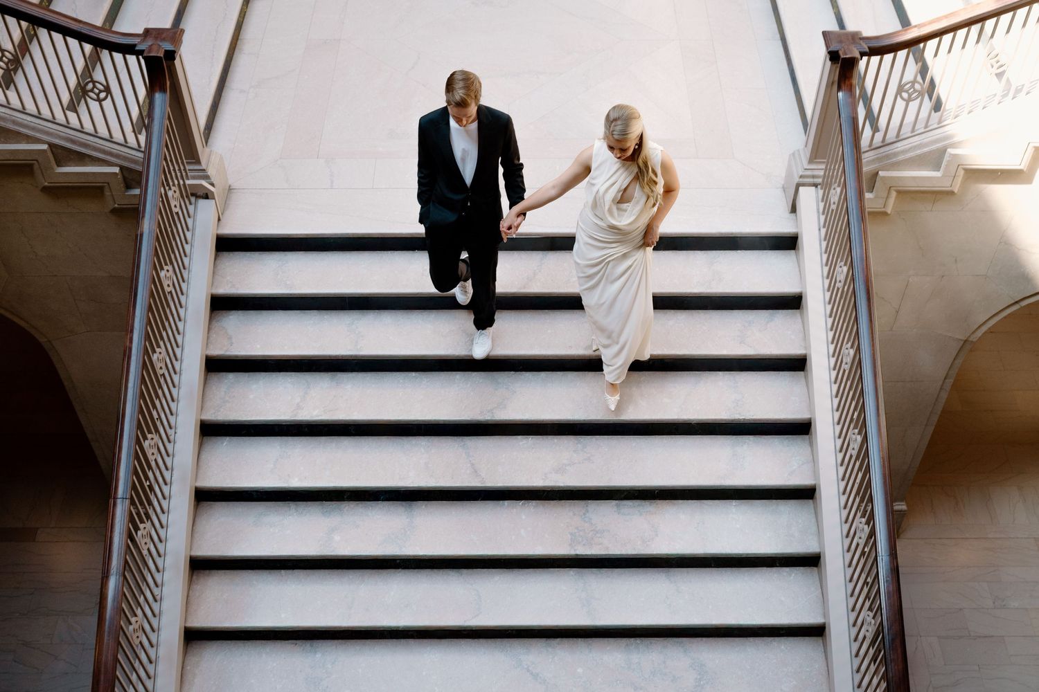 People walking down black and white striped steps in an artistic architectural setting.