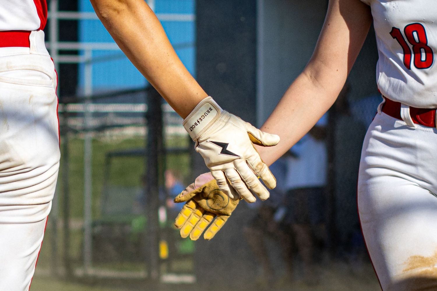Two baseball players touching gloves in a sportsmanship gesture during a game.