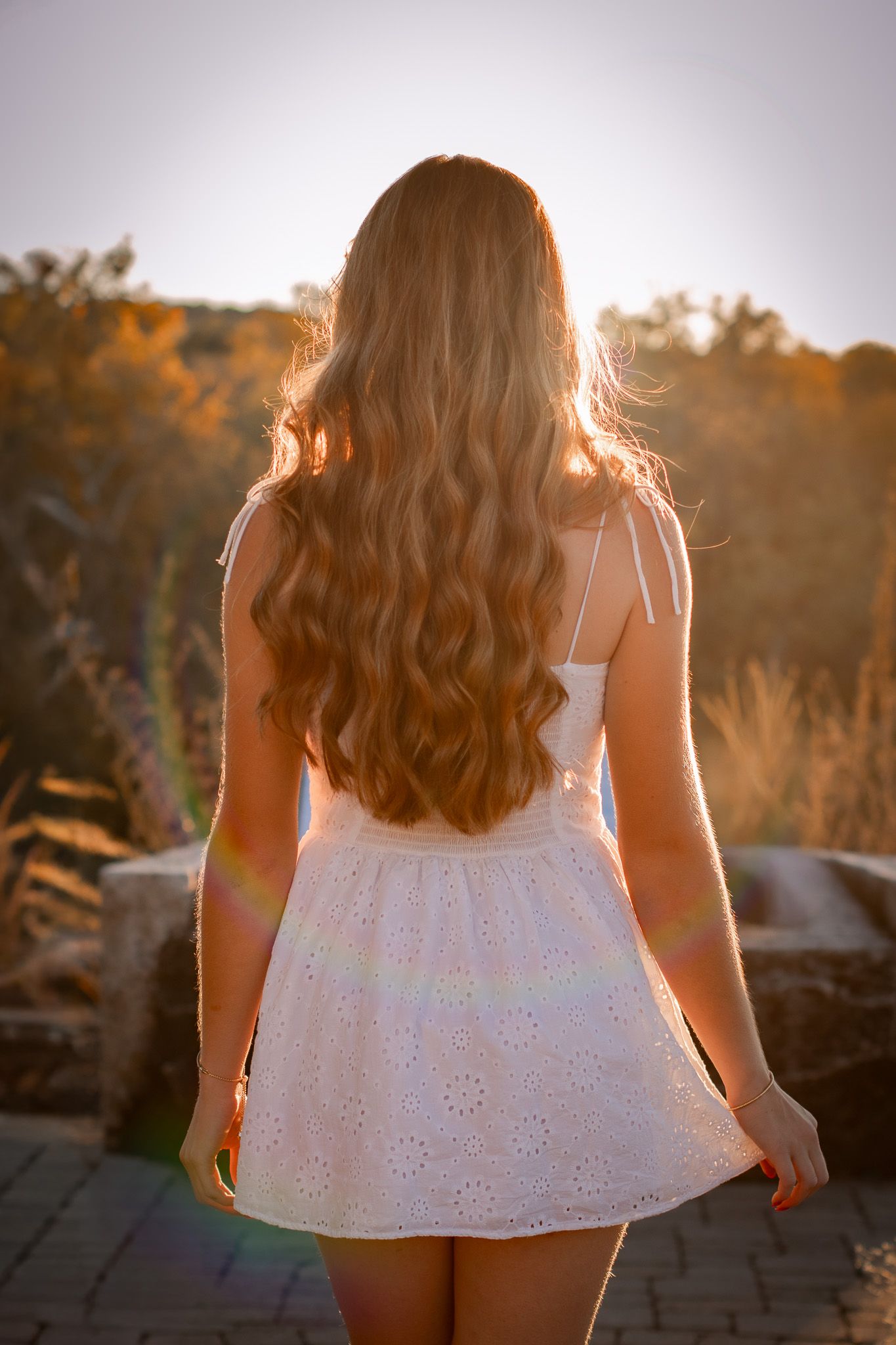 Back view of white eyelet dress during golden hour portrait session.