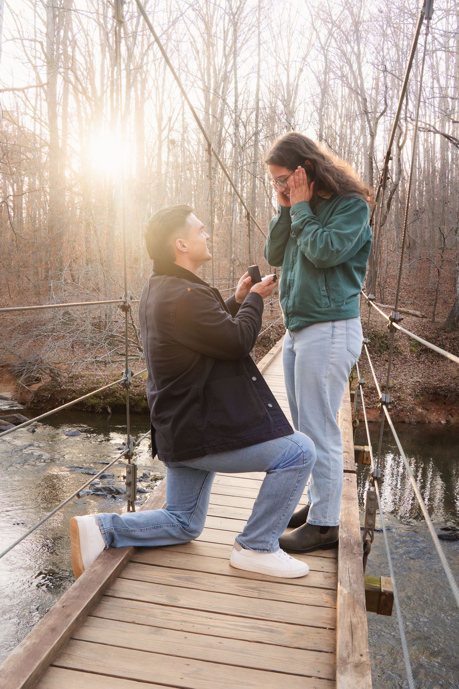 Surprise proposal moment captured on a wooden bridge during golden hour. Alex Faye Photography Alex Faye Media Wedding Photographer Raleigh