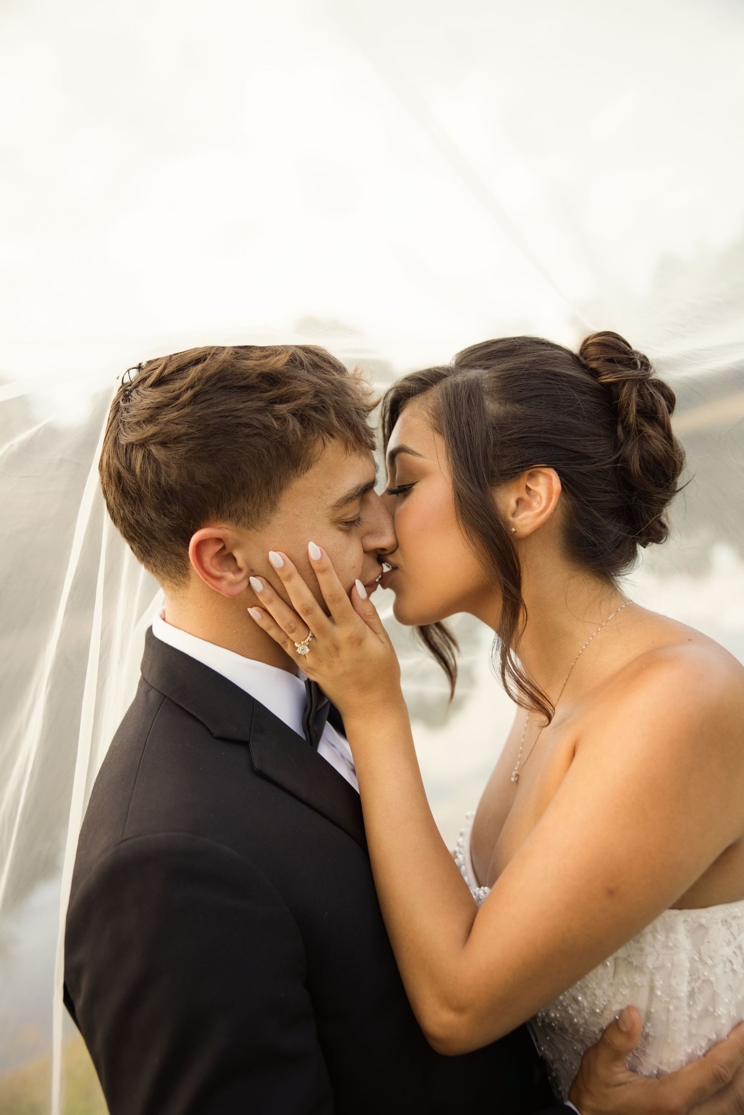 An intimate wedding portrait showing tender embrace under a flowing veil. Alex Faye Photography Alex Faye Media Wedding Photographer Raleigh