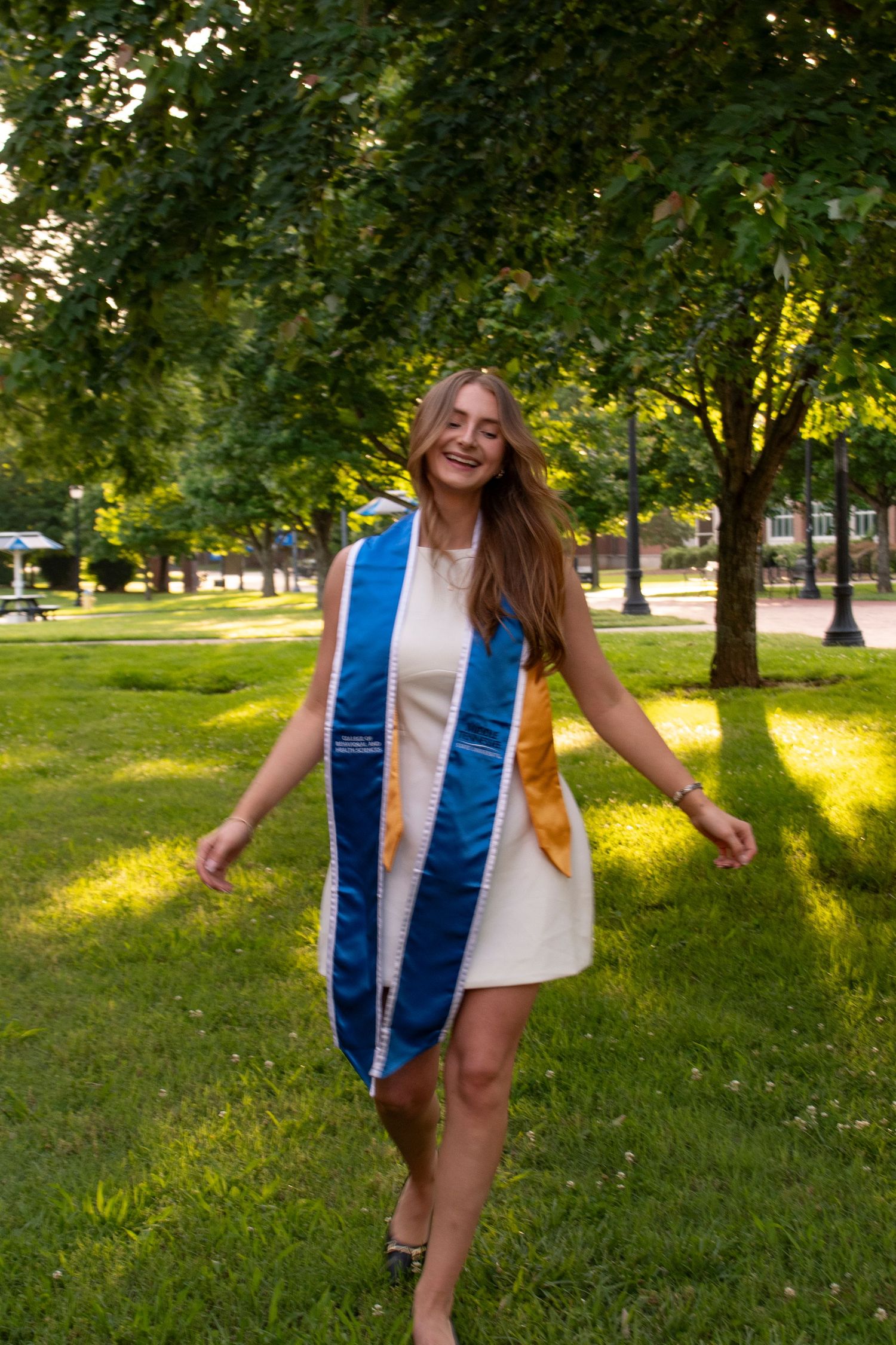 Graduate walking across campus during a portrait session