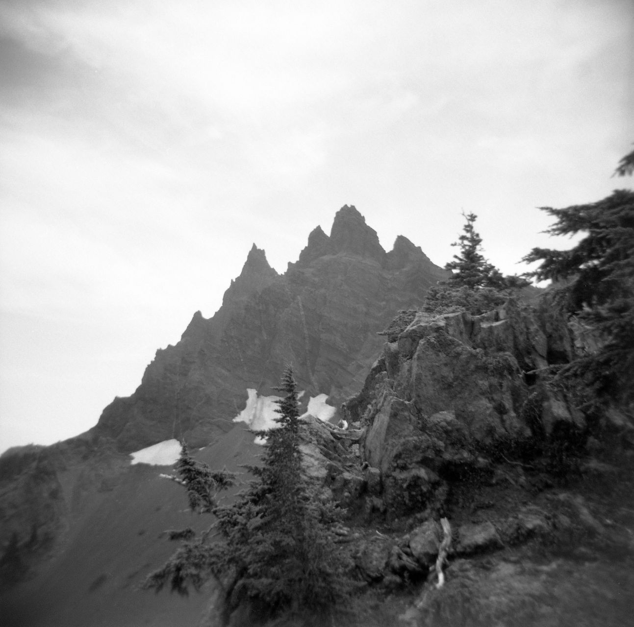 A black and white film Holga photograph of Three Fingered Jack, a jagged mountain on the Pacific Crest Trail in Oregon.