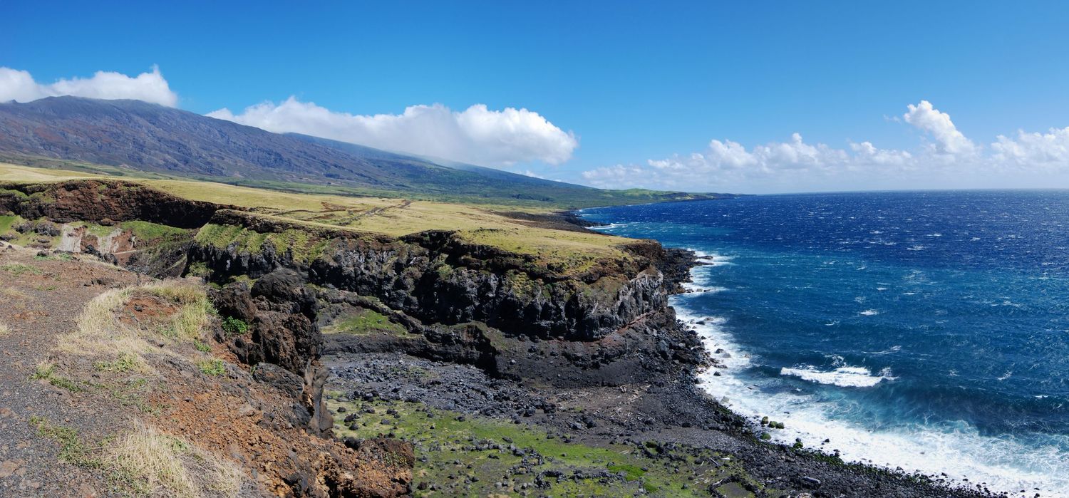 An ultrawide panoramic view of the dry southern Kaupo side of Maui, showing the slopes of Haleakala all the way down to seaside cliffs.