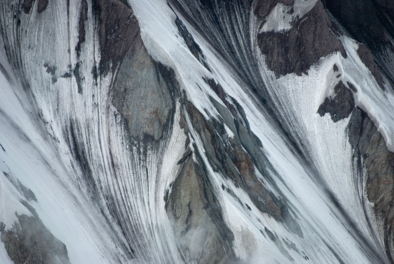 A closeup view of the delicate patterns of snow and ice draped on the very steep walls of the inside of Mount St. Helen's crater.