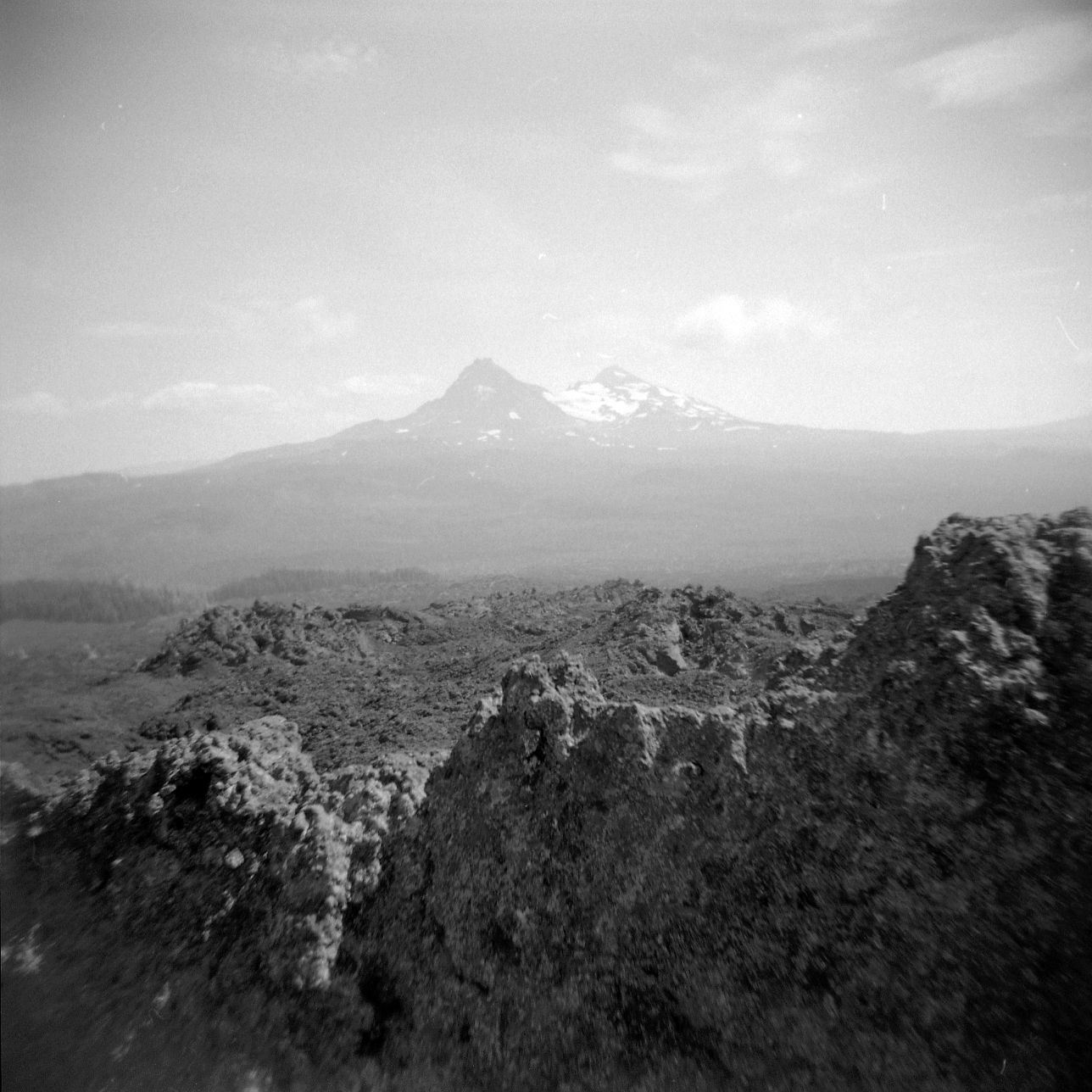 A black and white film Holga photograph of a dramatic open volcanic landscape near the Three Sisters Wilderness in Oregon.