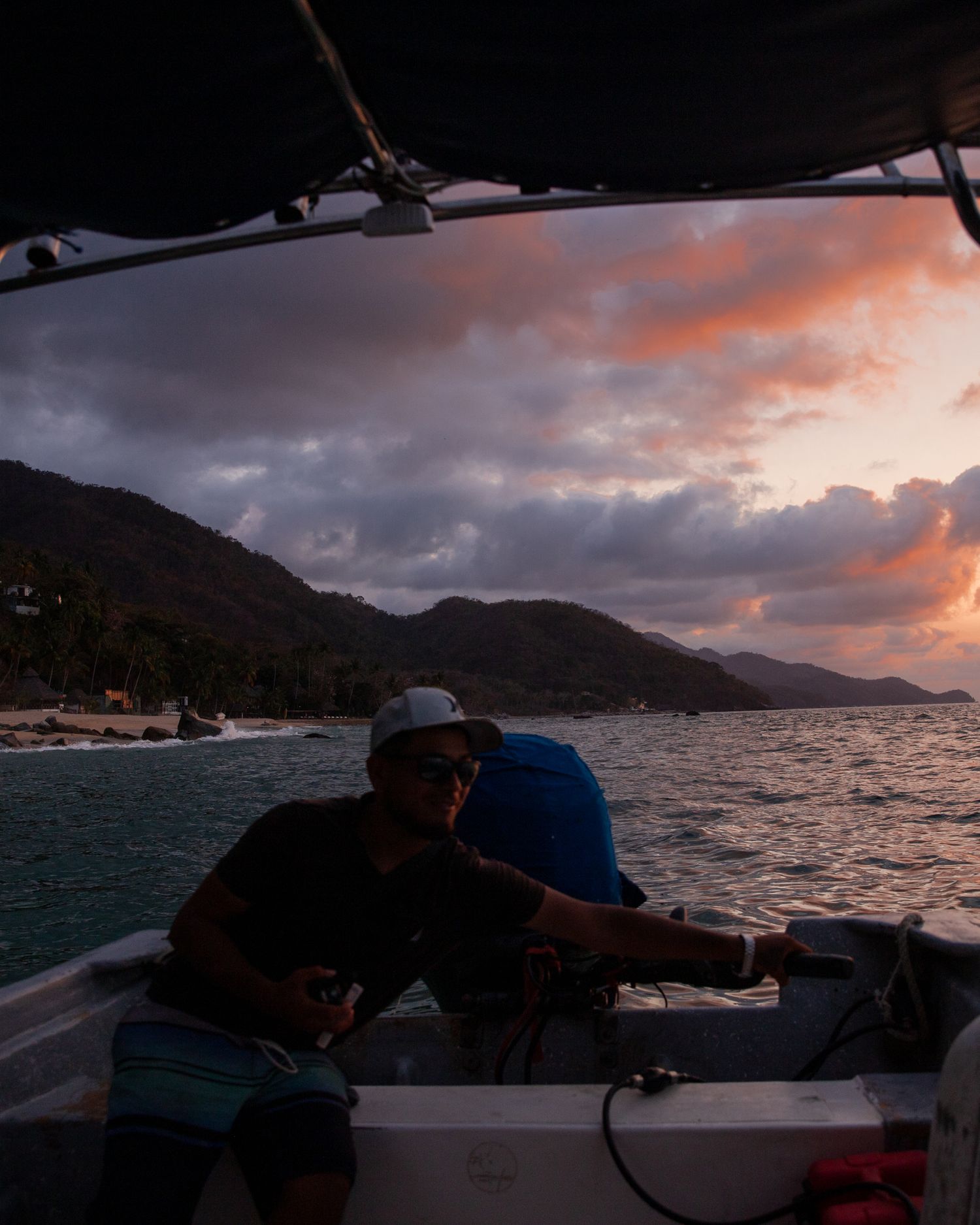 Travel photography image of silhouetted figures navigating a boat against a colorful sky. Editorial Travel image by Denver Photographer.