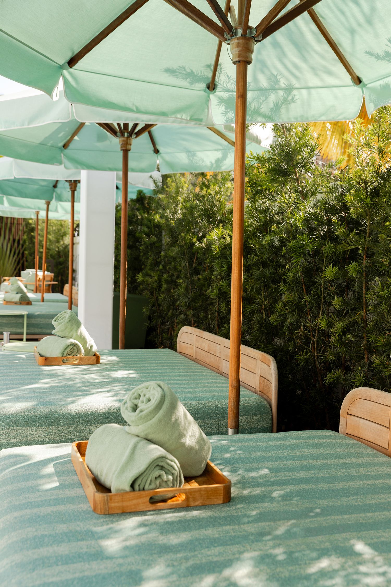 Towel art sculptures on a spa bed show a sequence of folding steps to create a decorative swan shape under a canopy.