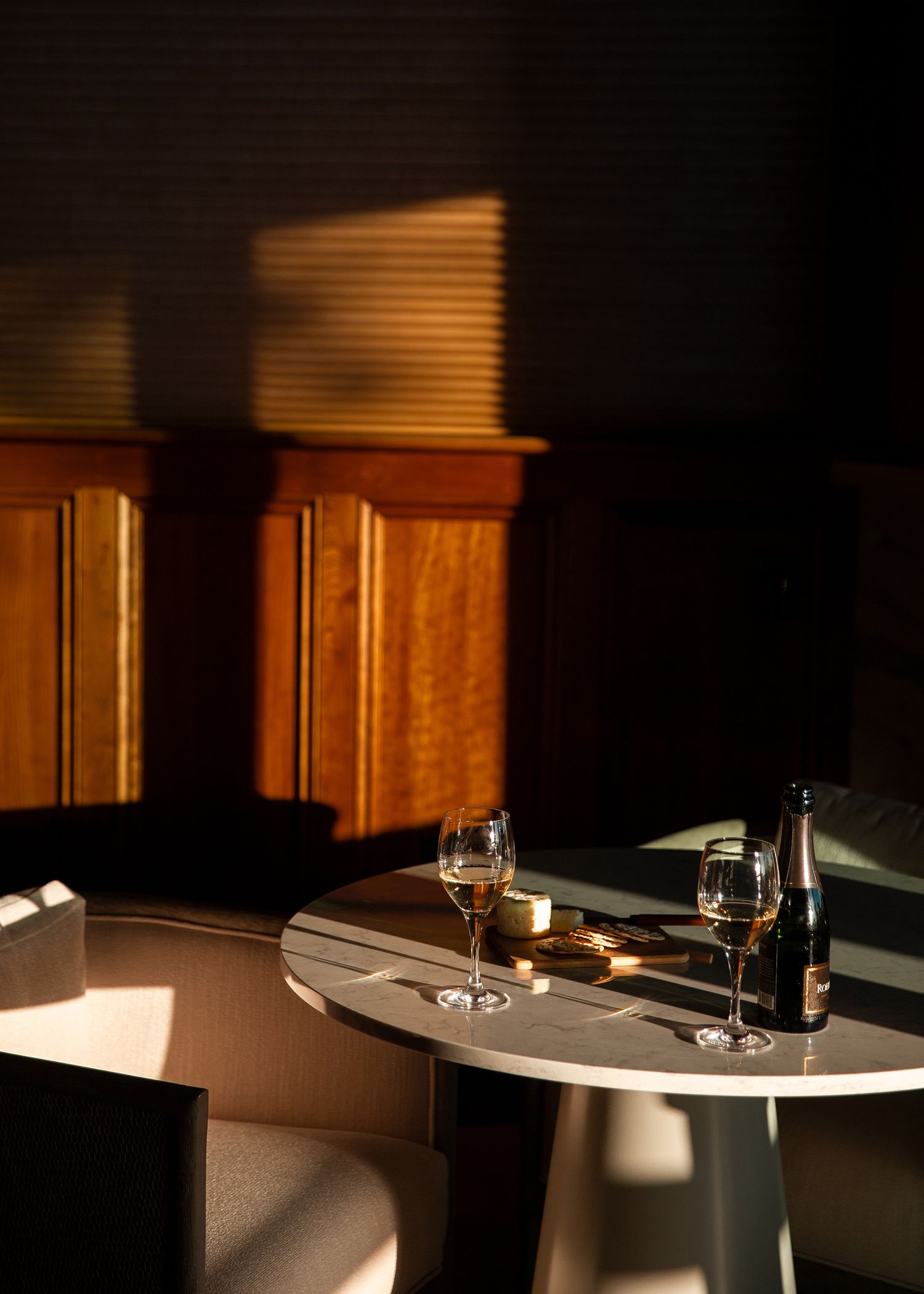 Wine and food image with a dark wood interior and moody lighting. Commercial photographer in Colorado for Luxury Hotels and Resorts.