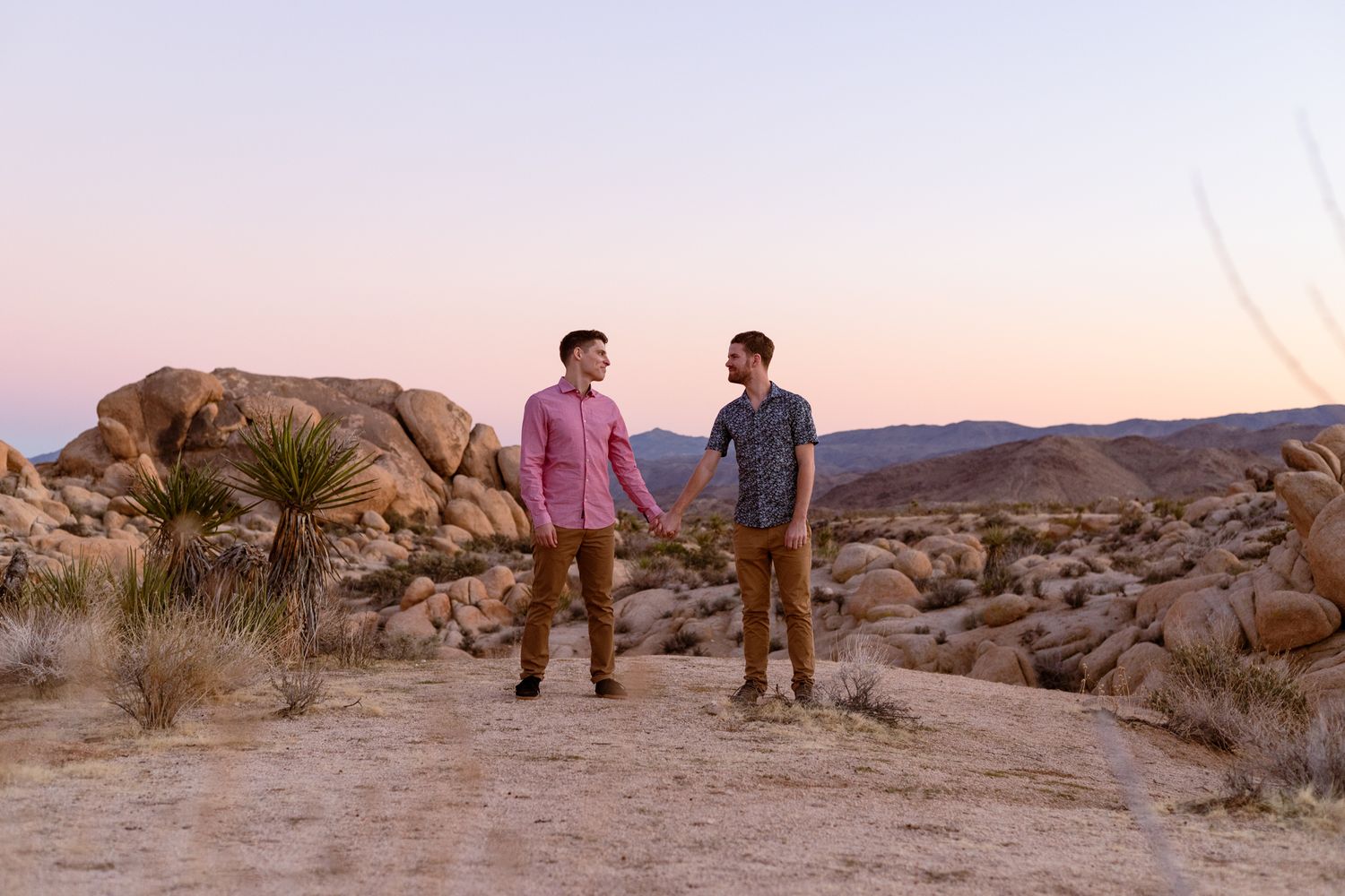 People walking together through rocky desert terrain at dusk.