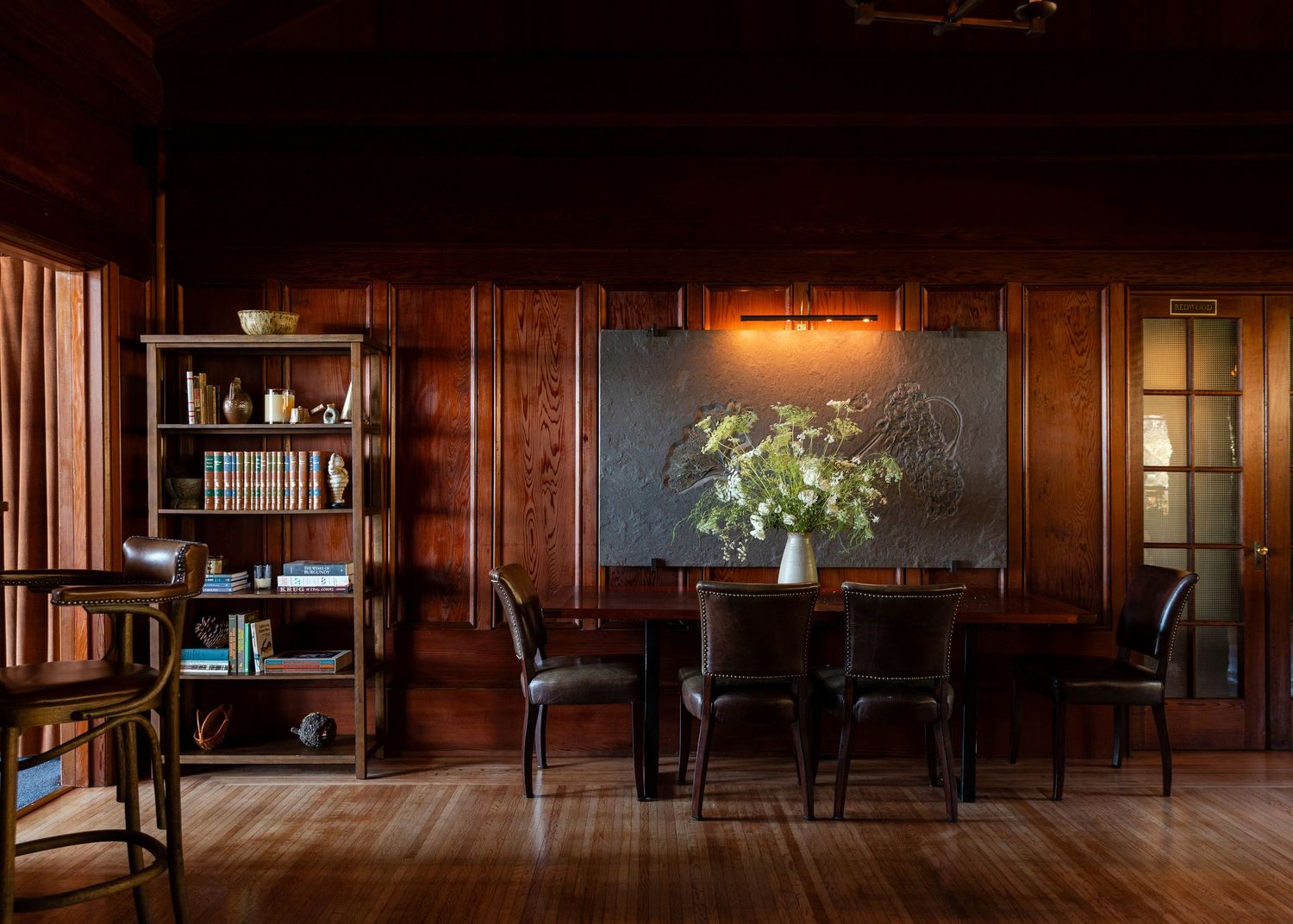 Dimly lit wooden interior photograph with bookshelves and warm ambient lighting shot by Denver photographer. Interiors and Travel photo.