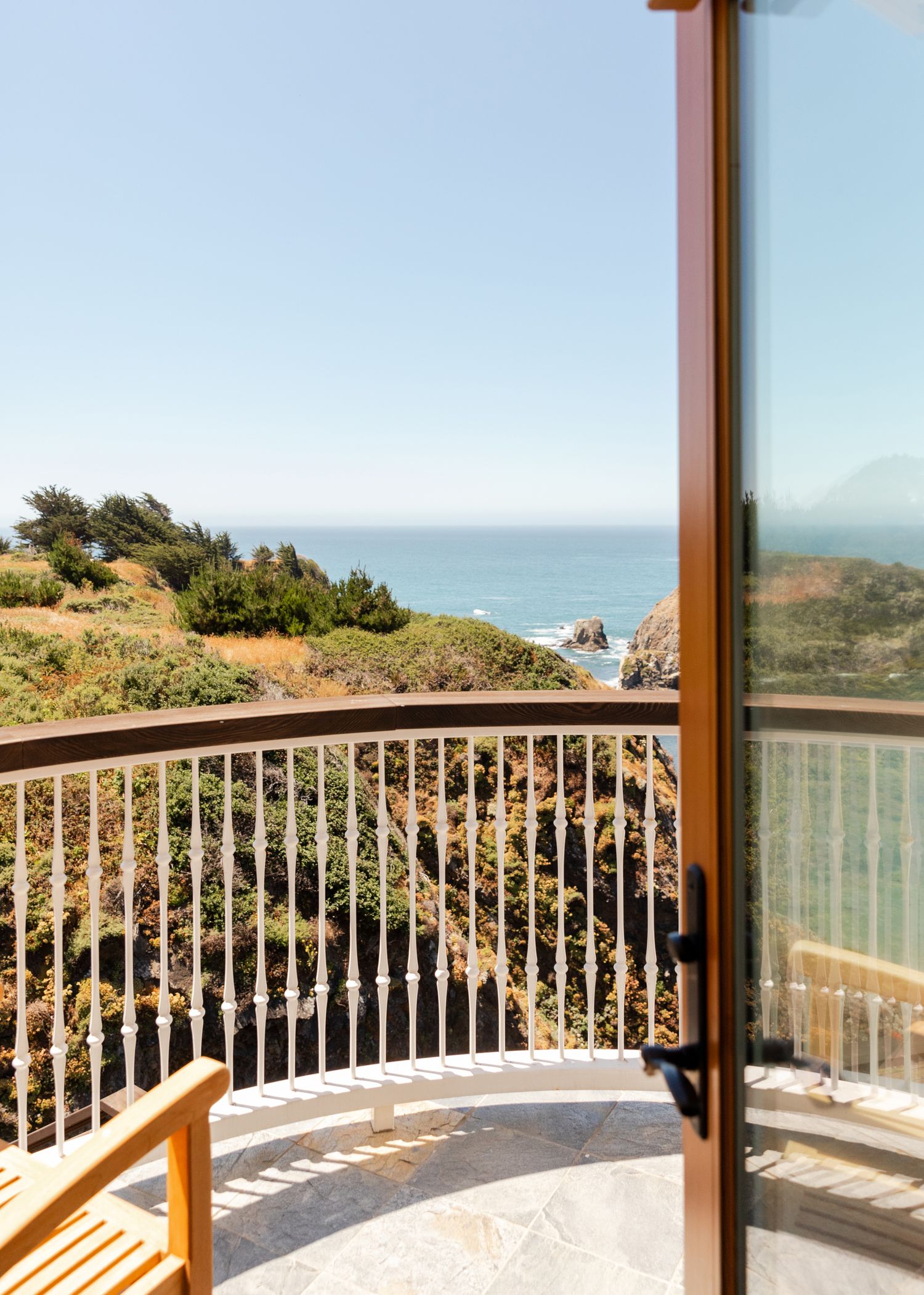 Scenic ocean view balcony with wooden railings and coastal landscape. Luxury coastal hotels and resorts by travel photographer Adrian Kahn.