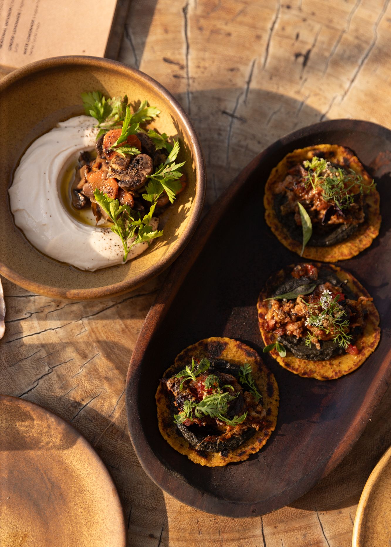 Editorial food image of gourmet tacos and dip served on rustic wooden table in dramatic lighting by travel photographer based in Denver CO.