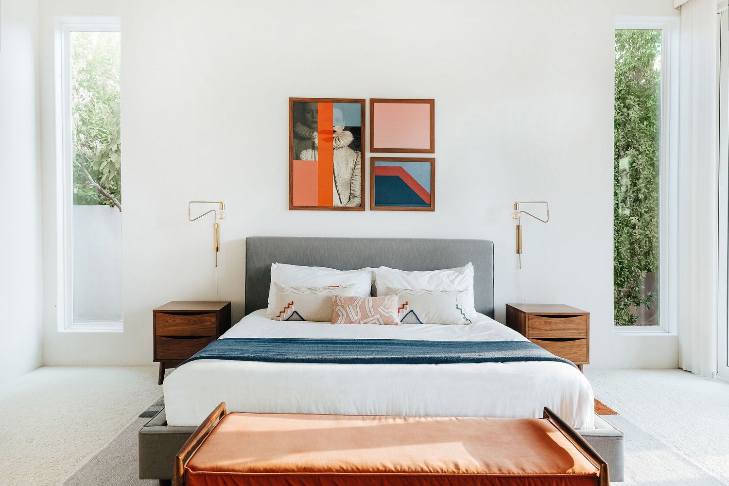 Minimalist white bedroom with large windows and modern furnishings.