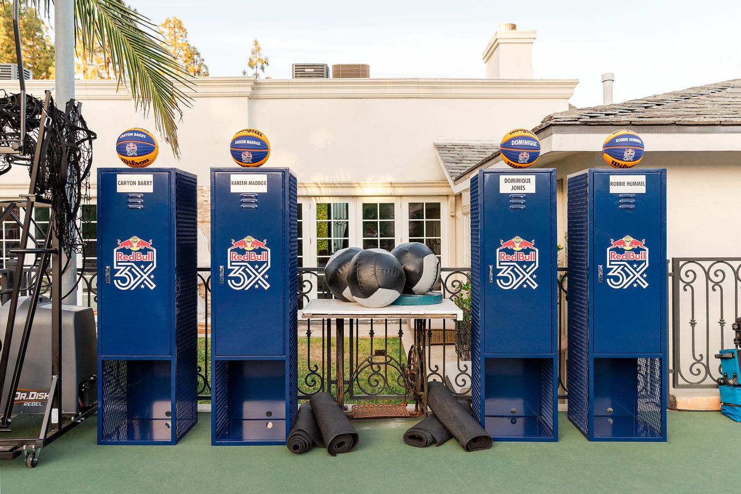Row of blue Pepsi vending machines lined up against a white building wall with palm trees visible.