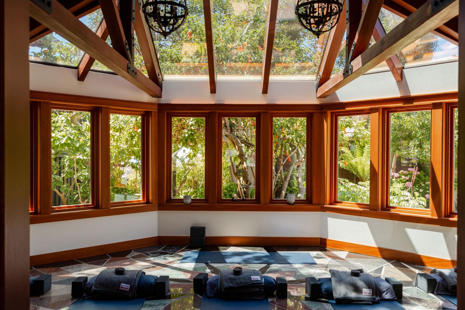 Sunlit meditation room with wood-framed windows and skylight ceiling. Luxury hospitality photographer based in Aspen, Colorado.