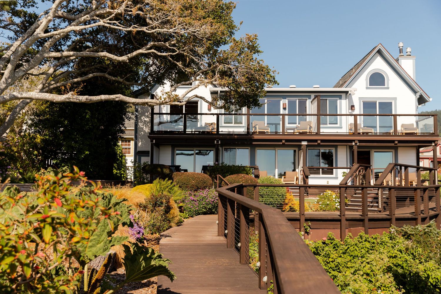 Scenic oceanfront houses with wooden decks overlooking the Pacific coast.