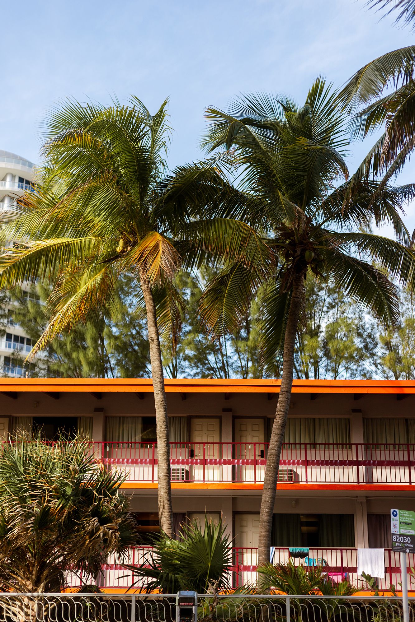 Palm trees and orange-accented motel architecture create a retro tropical scene.