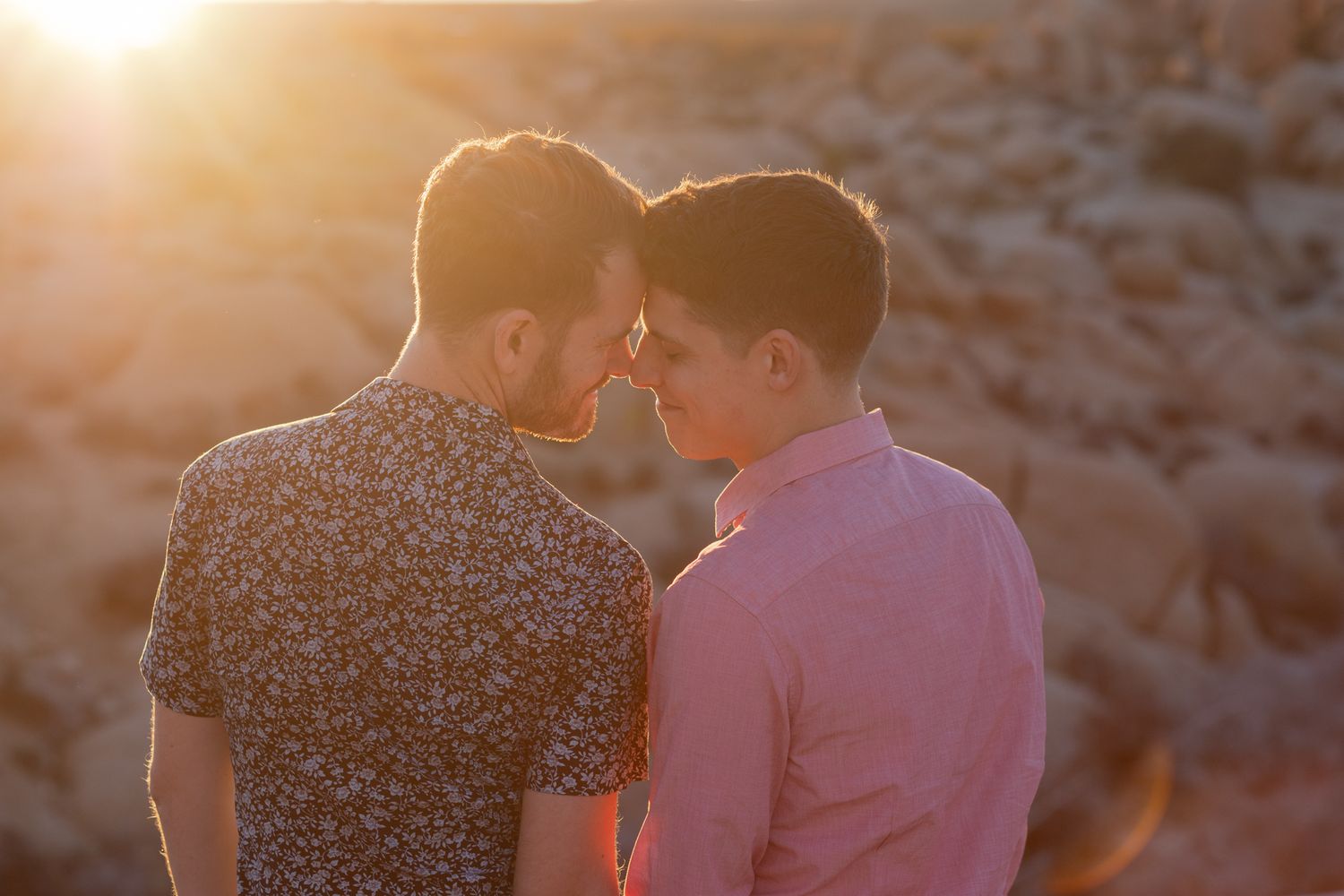 Romantic sunset scene with backlit couple against golden sky and ocean mist.