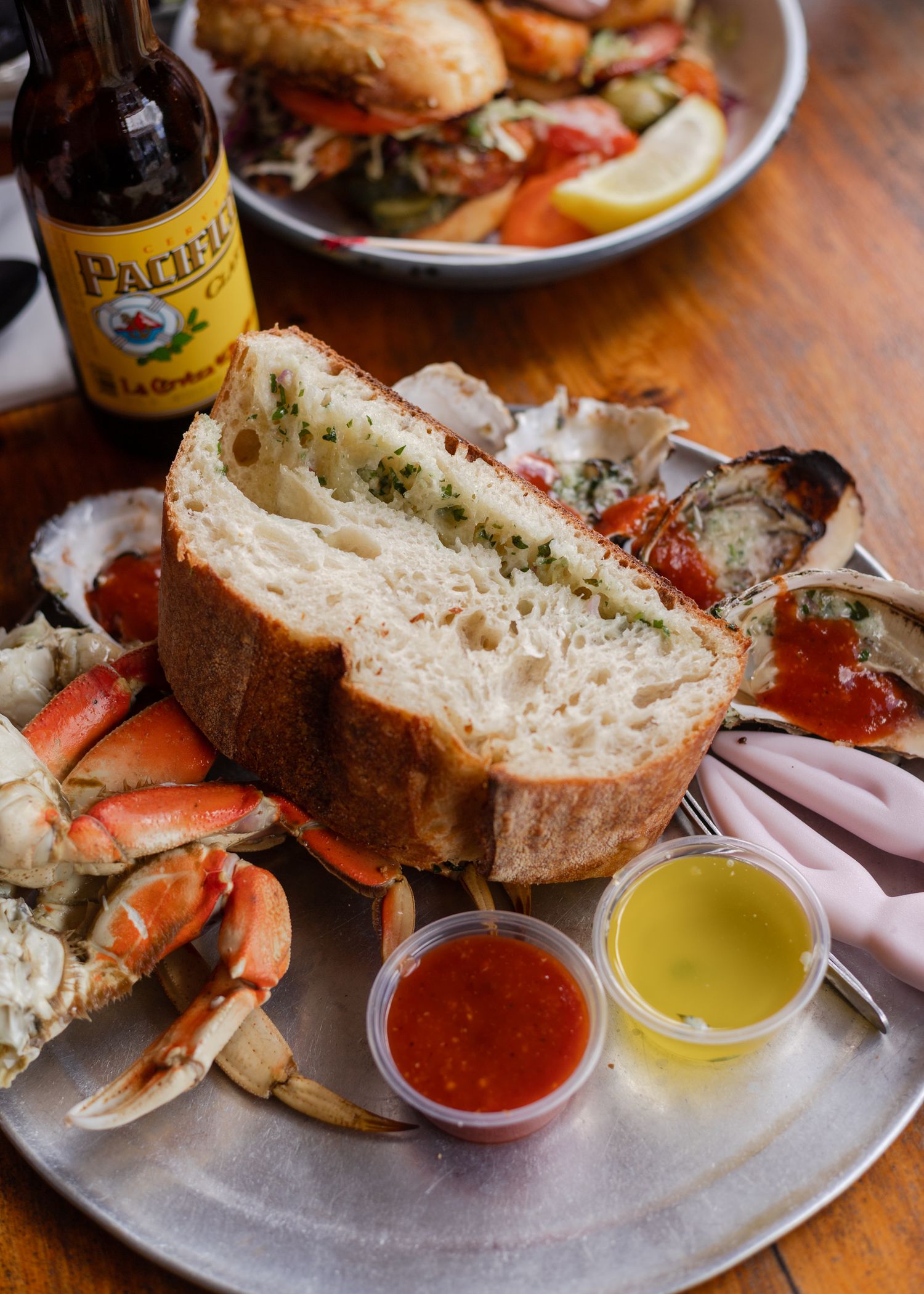 Fresh crab with bread and dipping sauces served on a gray plate in coastal Northern California. Editorial travel and food photography.