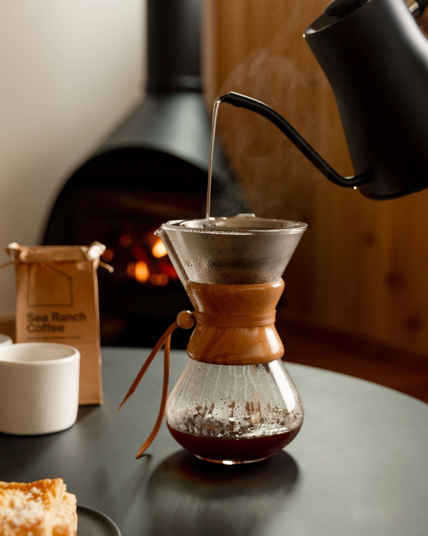 A sequence of coffee brewing steps showing a Chemex pour-over coffee maker with hot water being poured over grounds.