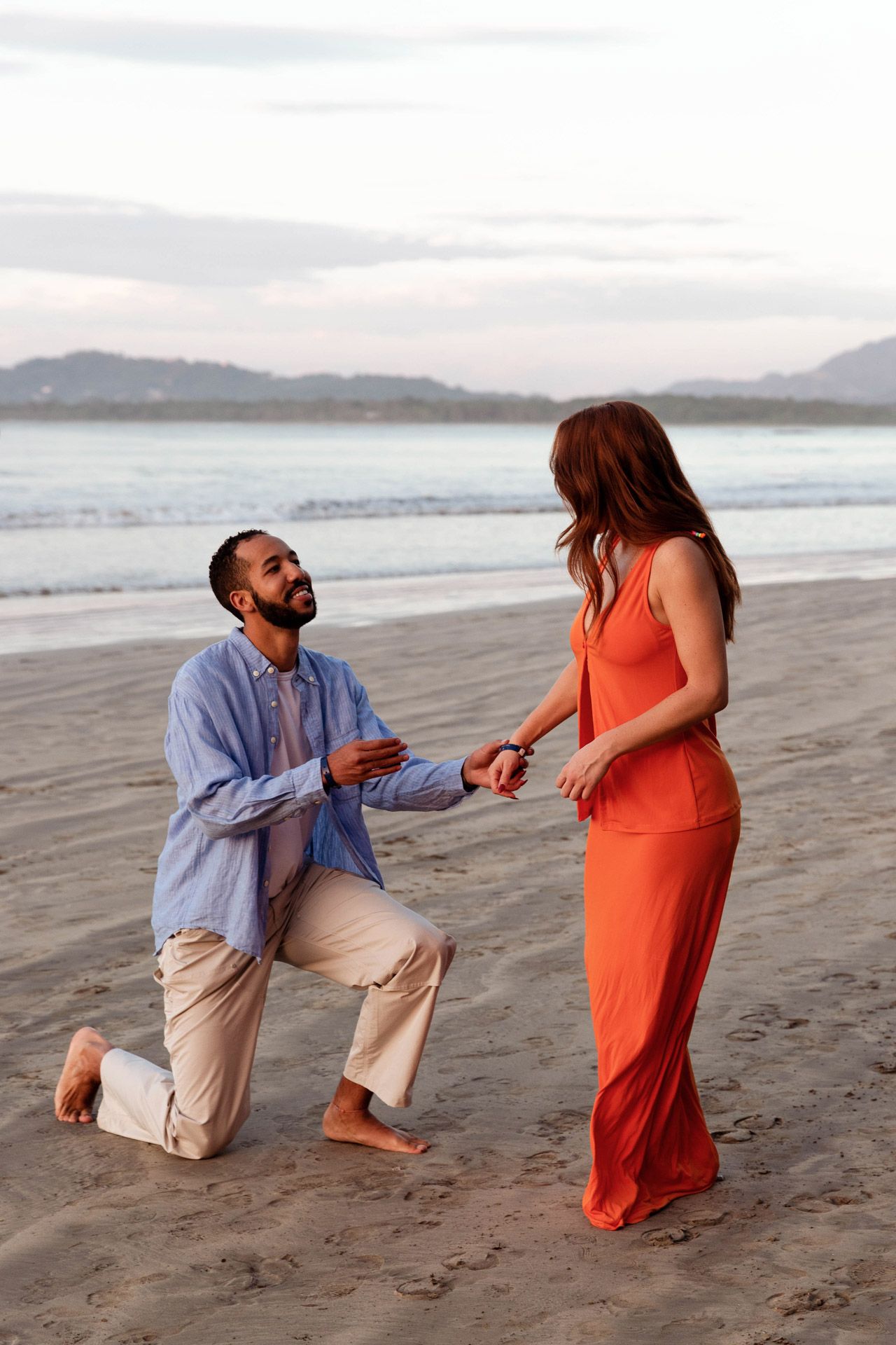 A romantic beach proposal sequence showing a couple during a surprise engagement moment.