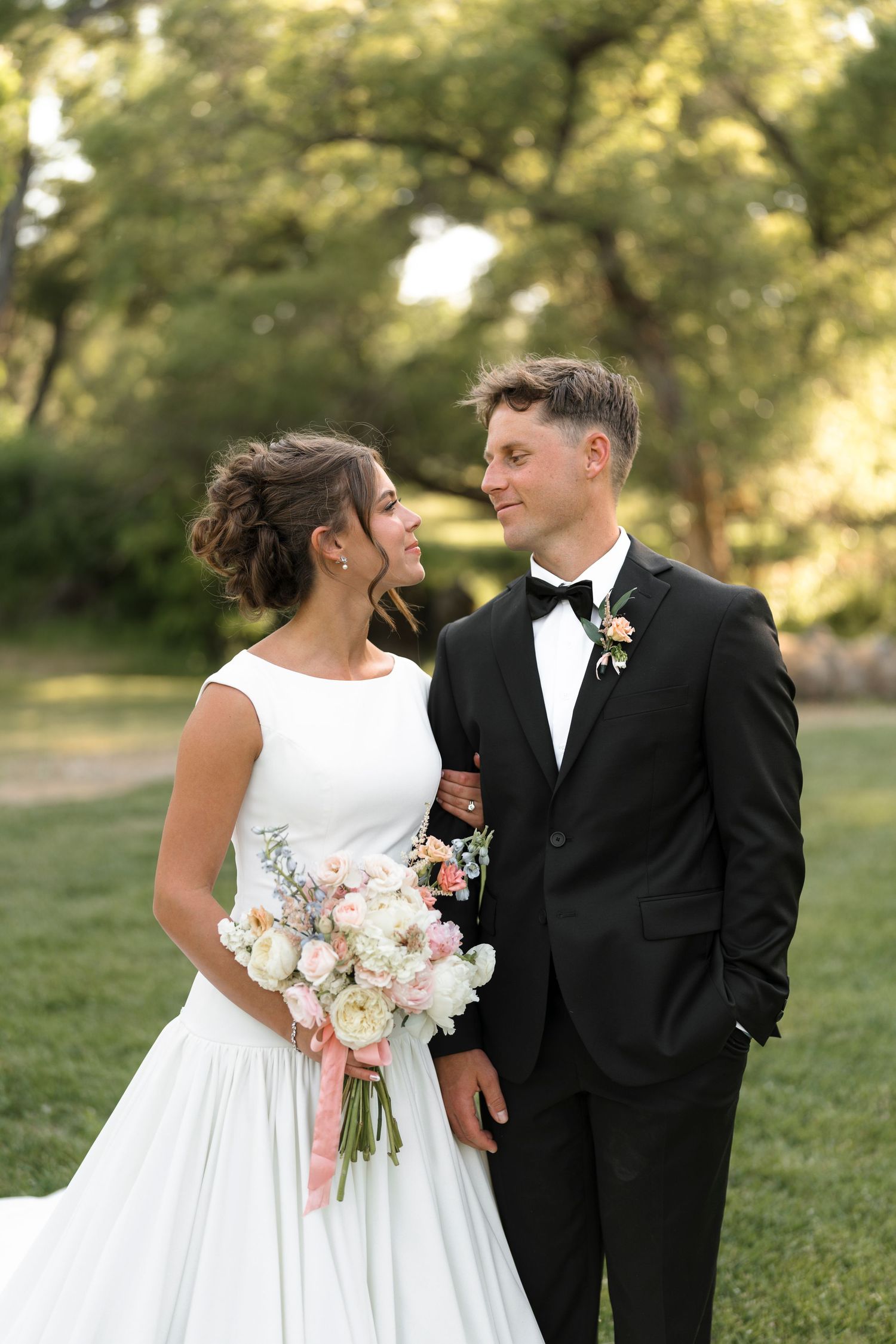 A romantic wedding couple shares intimate moments in an outdoor garden setting during their photo session.