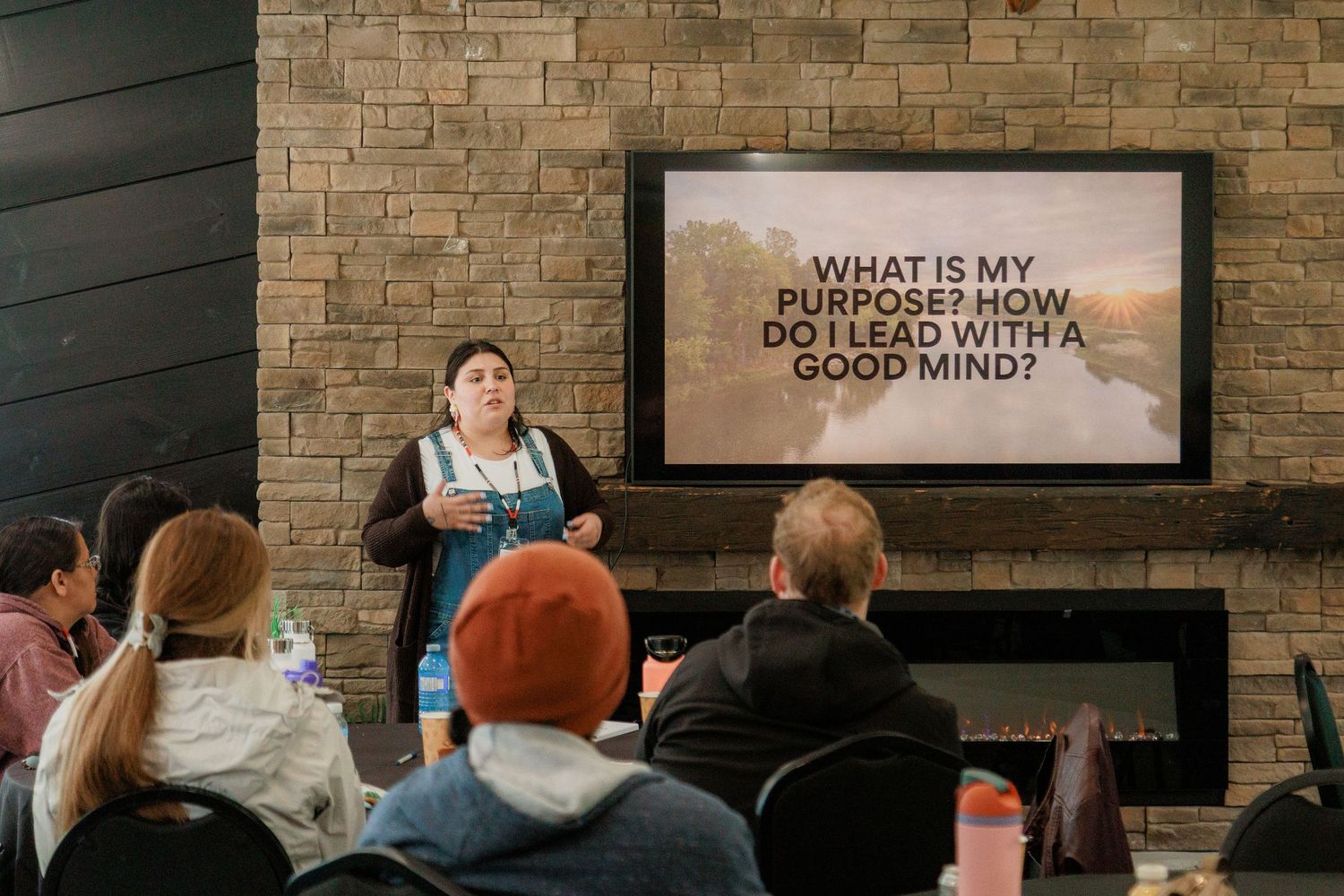 A speaker presents leadership workshop on purpose and leading with a good mind, displayed on screen behind her.