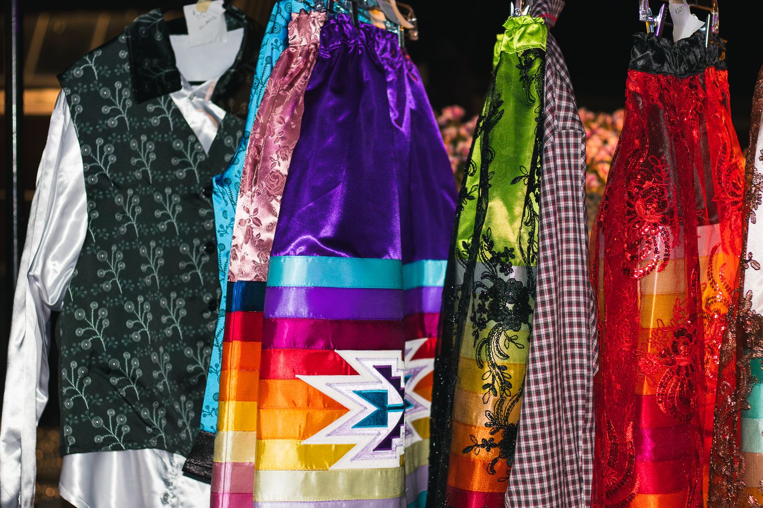 Colorful array of dresses and garments hanging on display.