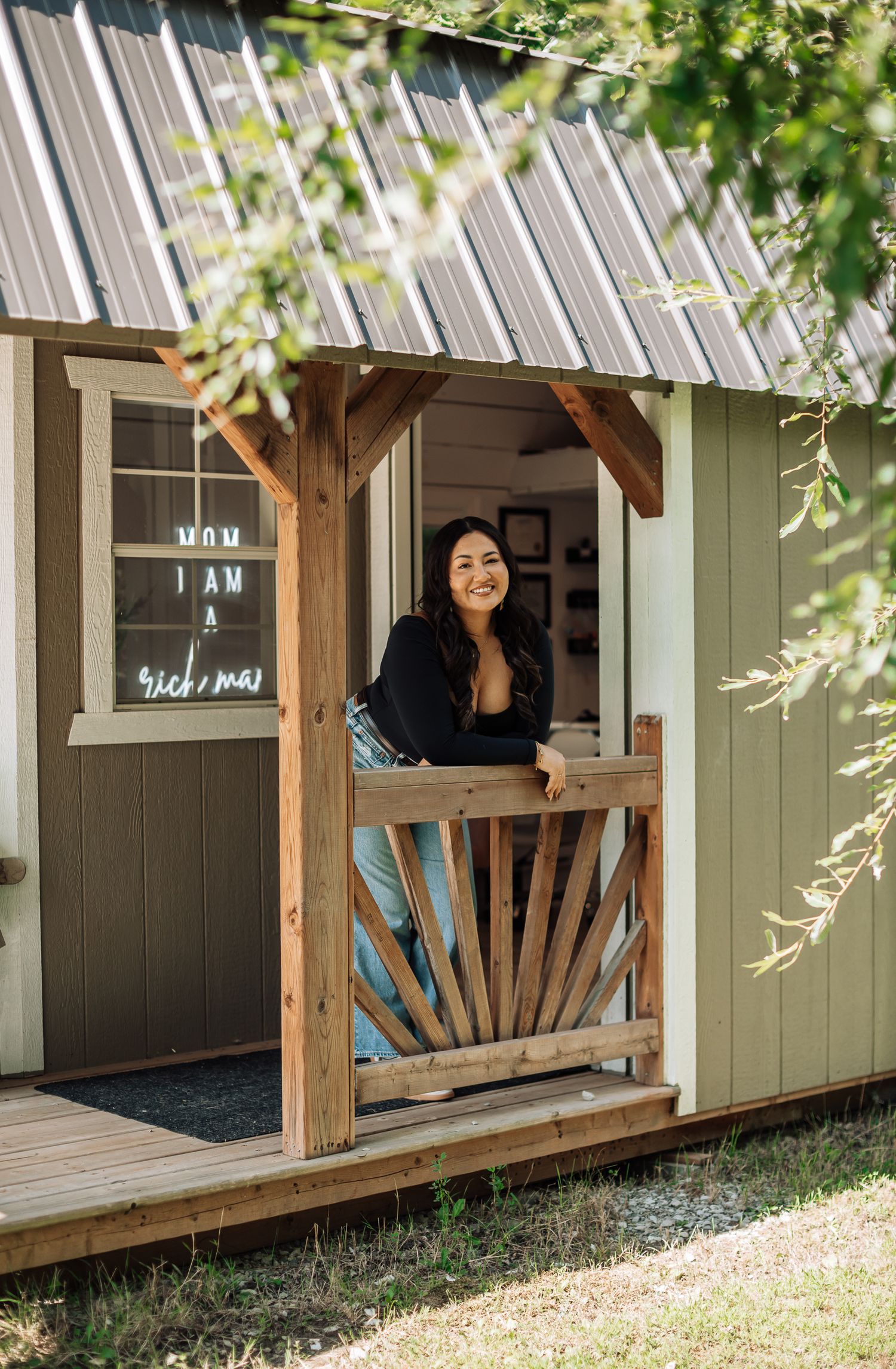 View of a charming green garden shed with wooden posts and natural lighting.