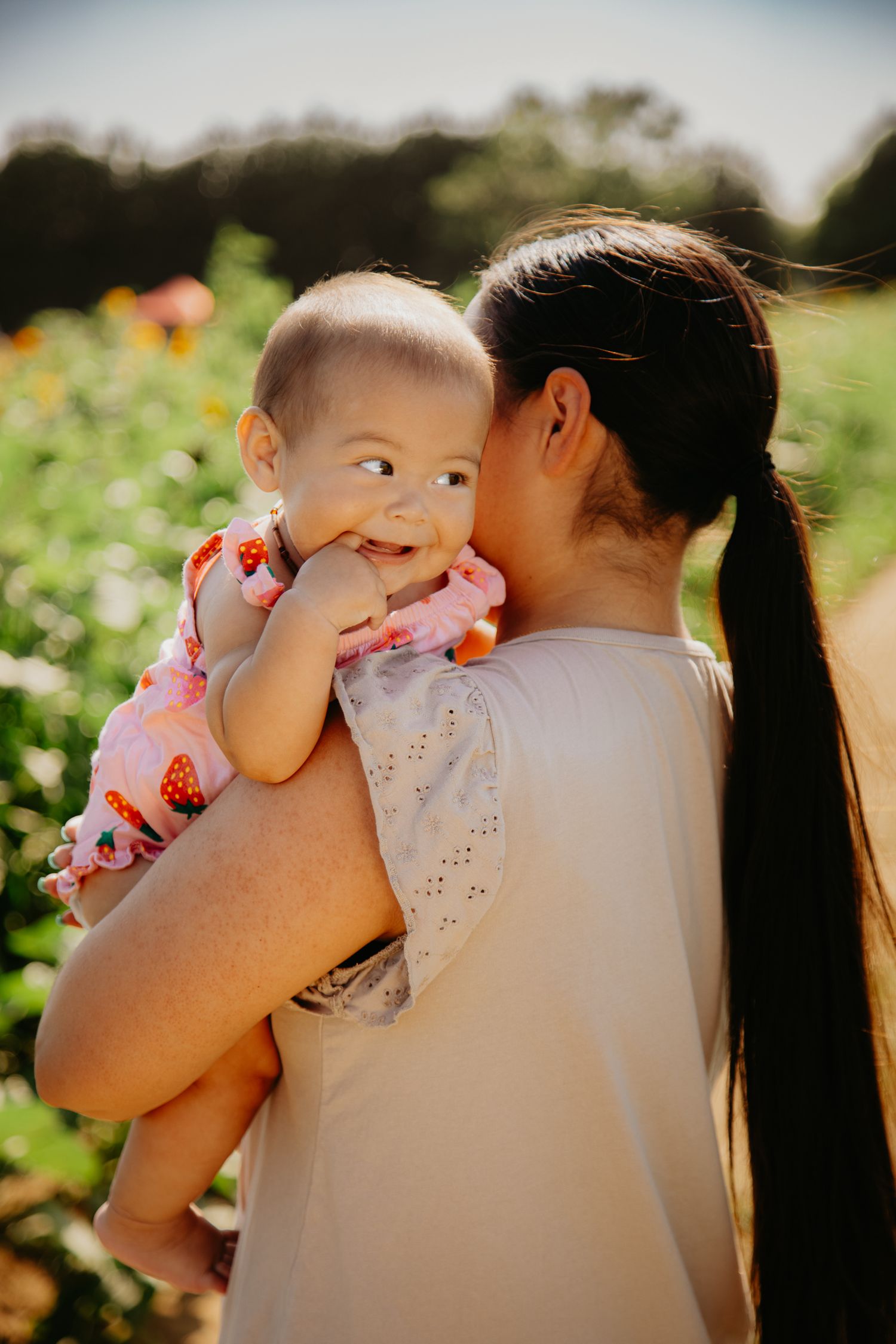 Tender moment captured in golden sunlight with floral background.