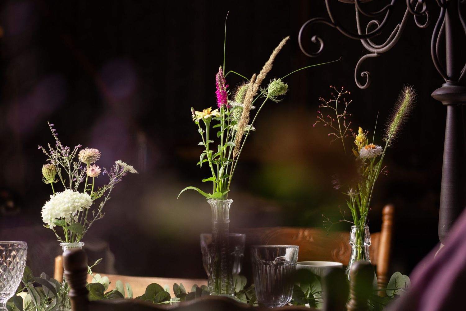 Elegant table settings with delicate floral arrangements and candlelight for an evening event.