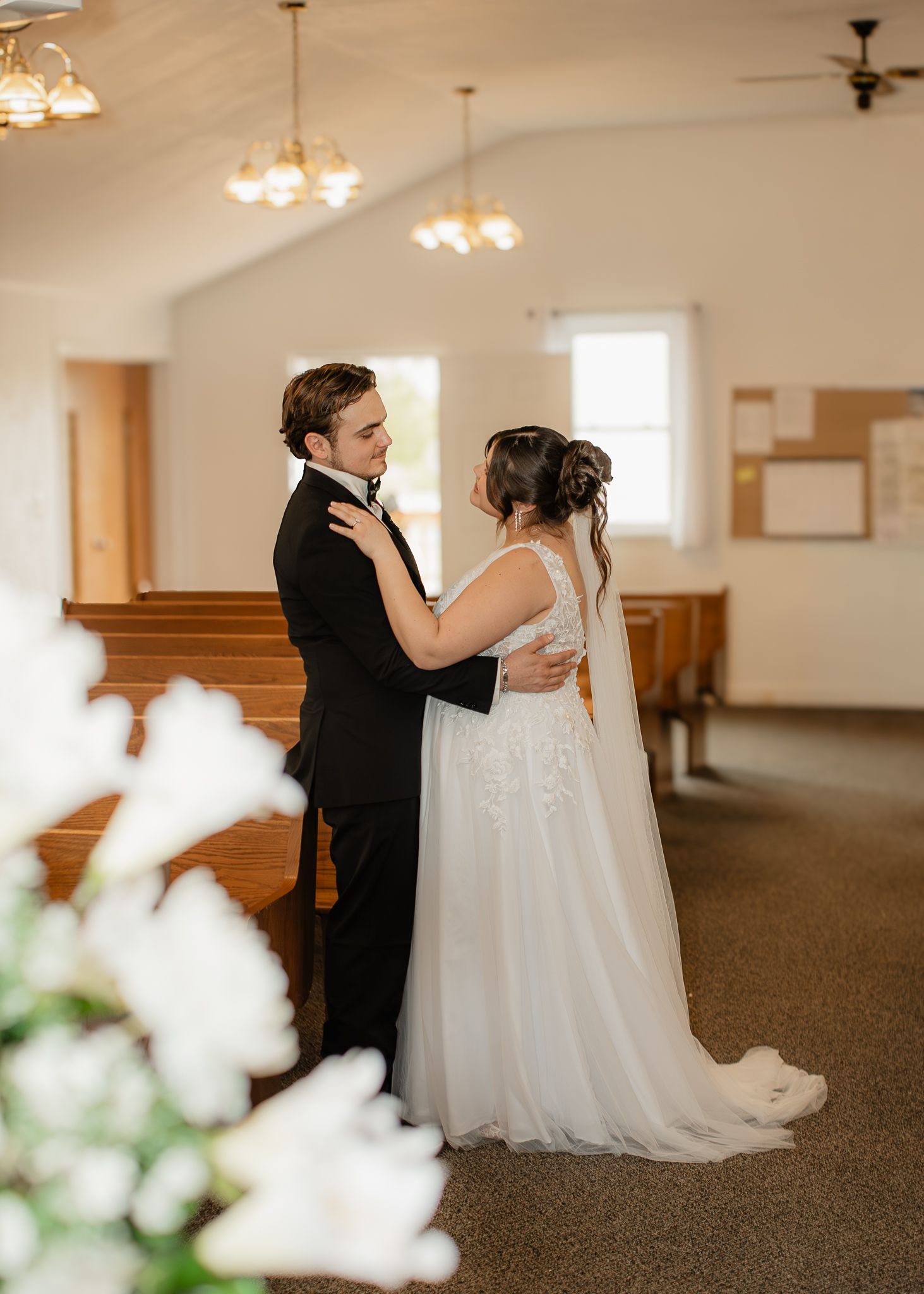 Bride and groom sharing a tender first look moment inside a small chapel.