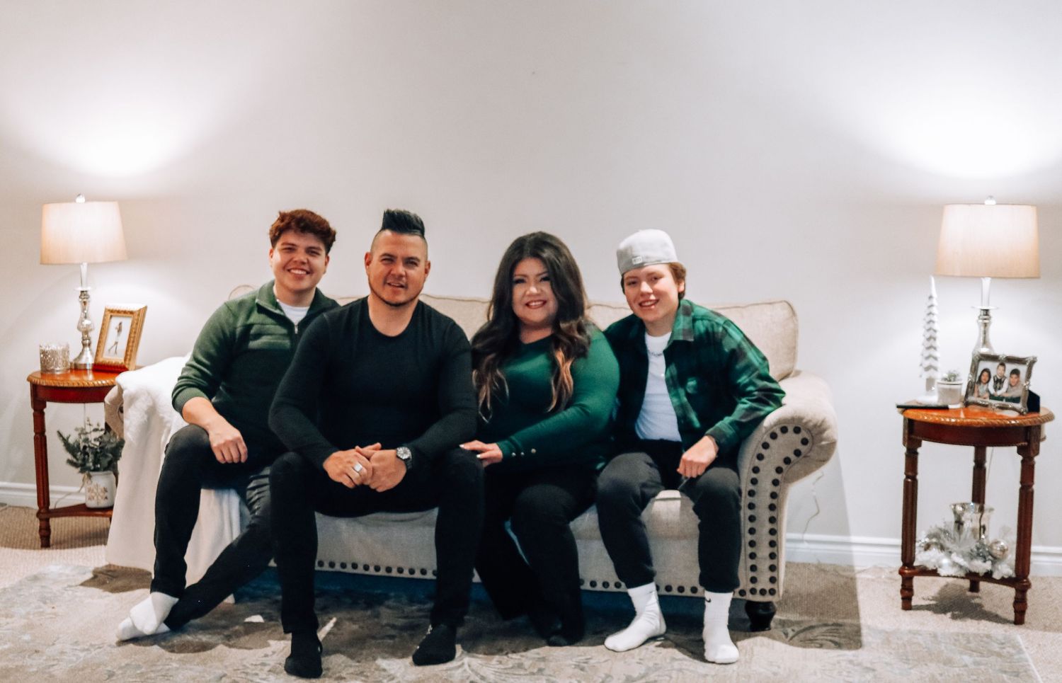 A bright modern living room with people gathered for holiday photos.