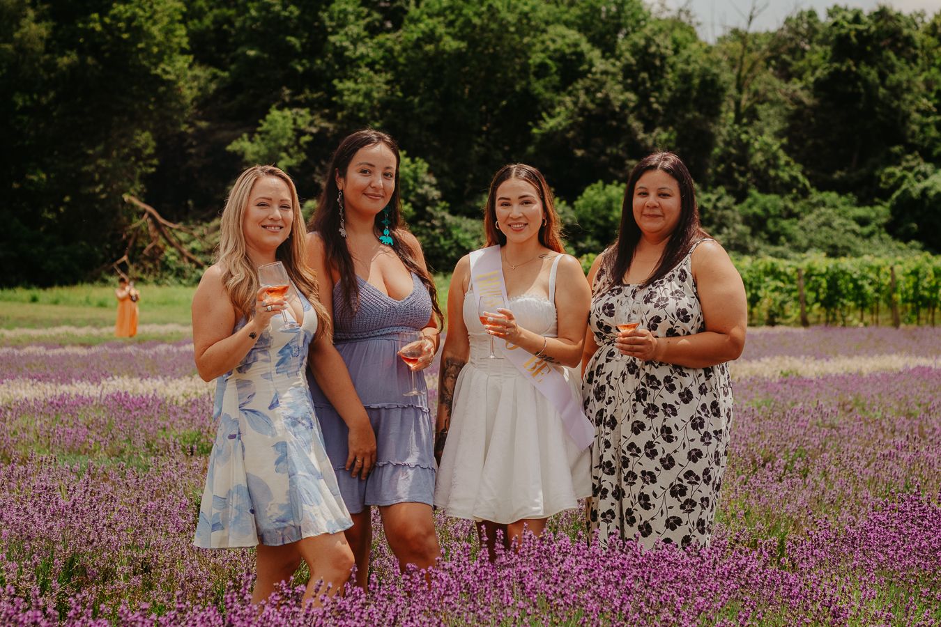 Friends celebrating in garden with purple flowers and greenery in background.