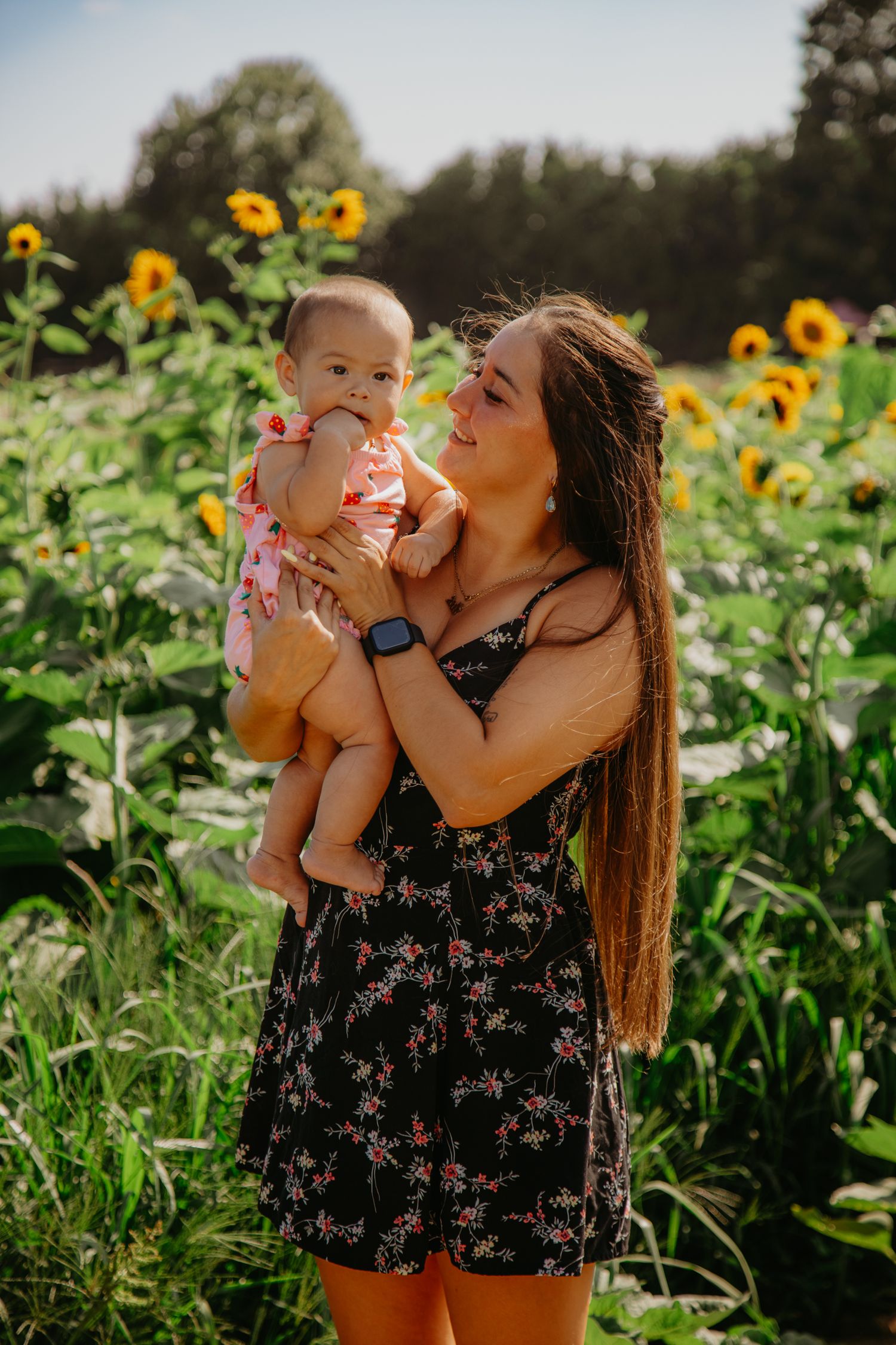 Playful family moment captured in a blooming sunflower garden.