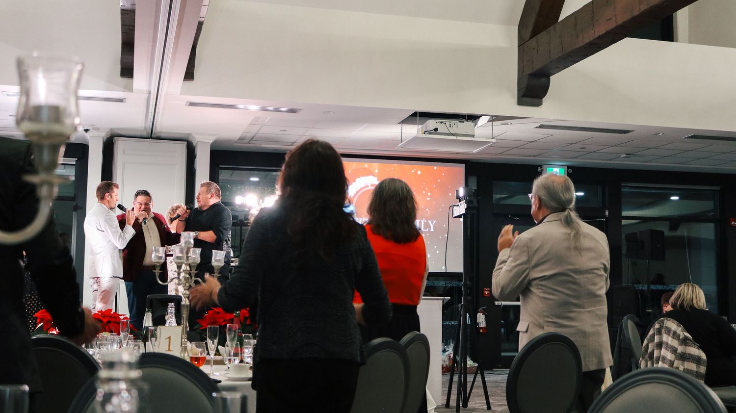 Low-light panoramic view of an indoor event space with scattered seating and lighting fixtures.