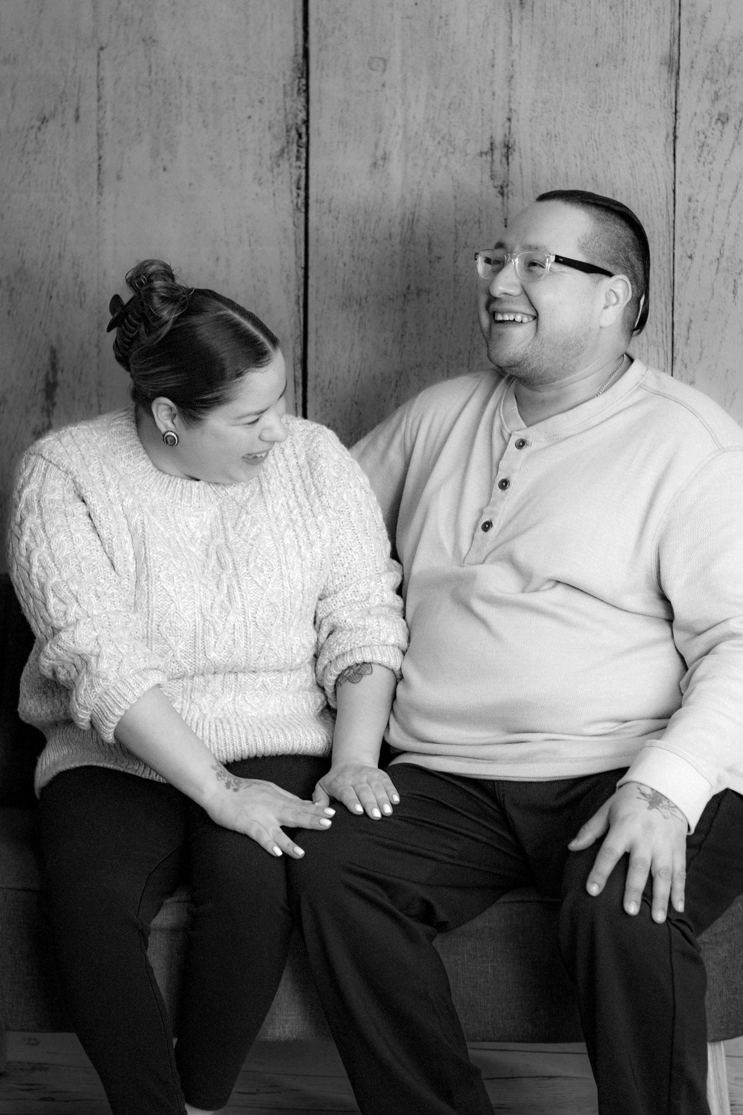 Black and white series of a couple sitting close together on a couch sharing intimate moments.