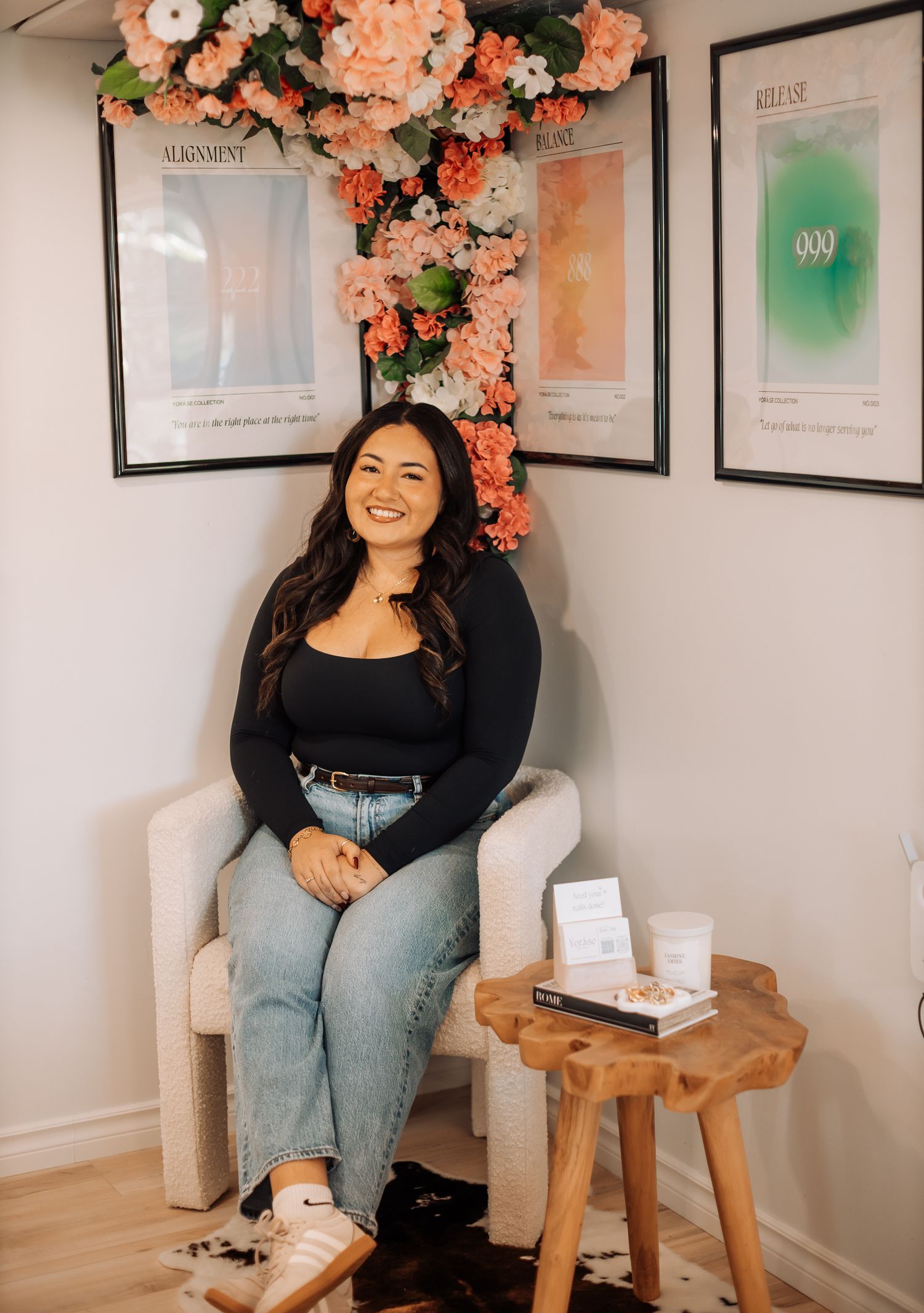 A nail salon interior decorated with peach flowers and framed artwork on the walls.
