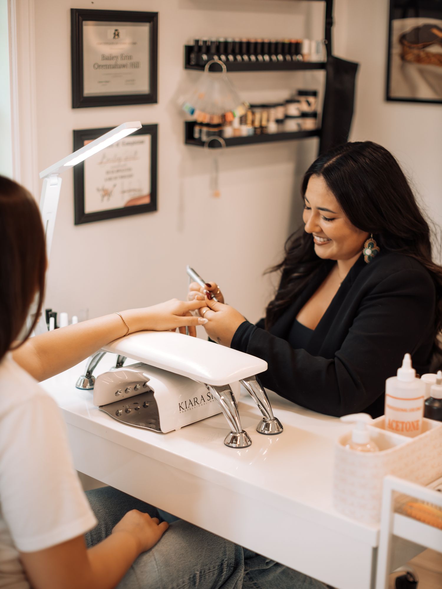 Professional nail service being performed at a white manicure station.